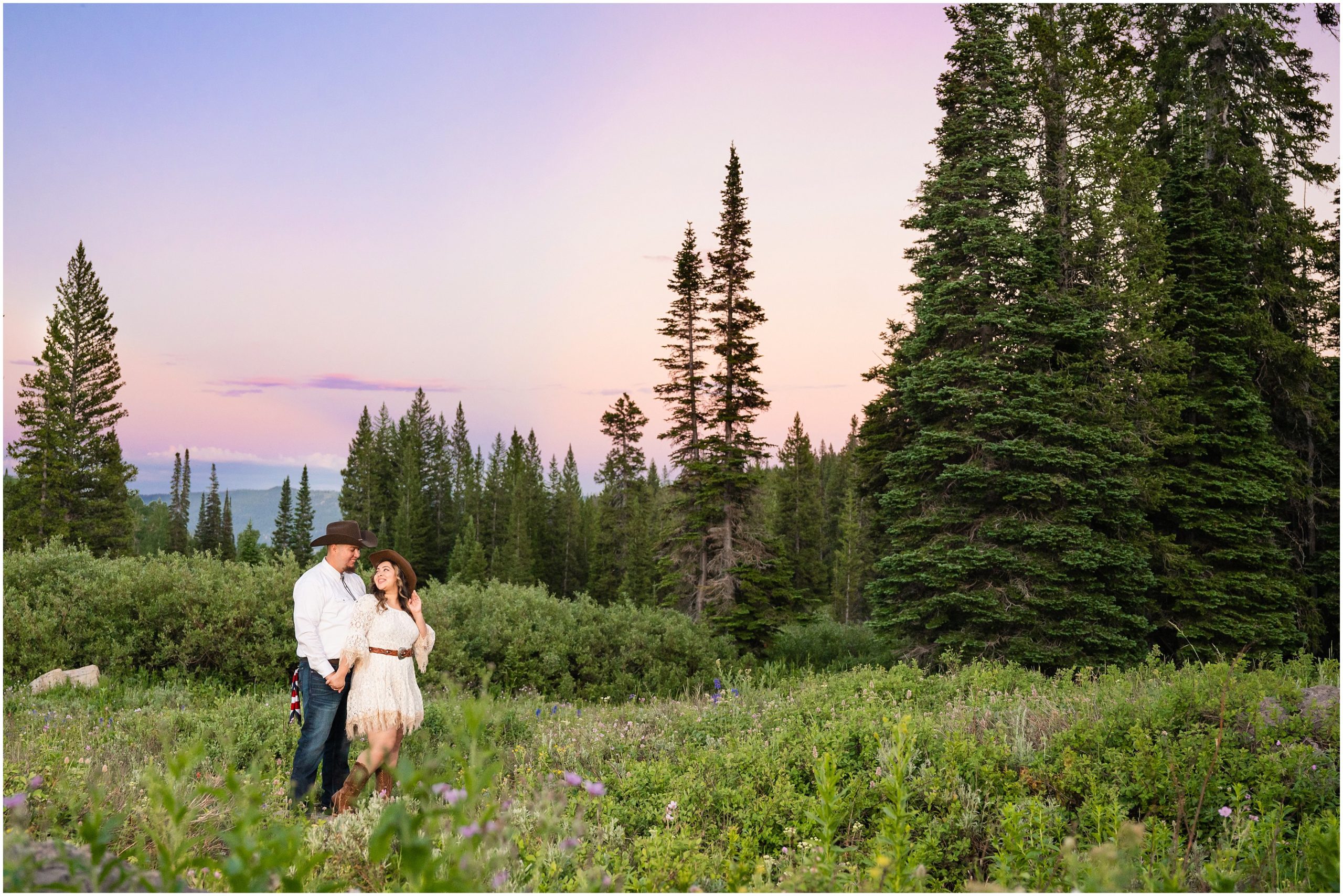 Couple in the mountains at sunset in western outfits during engagement session | Tony Grove Western Destination Engagement