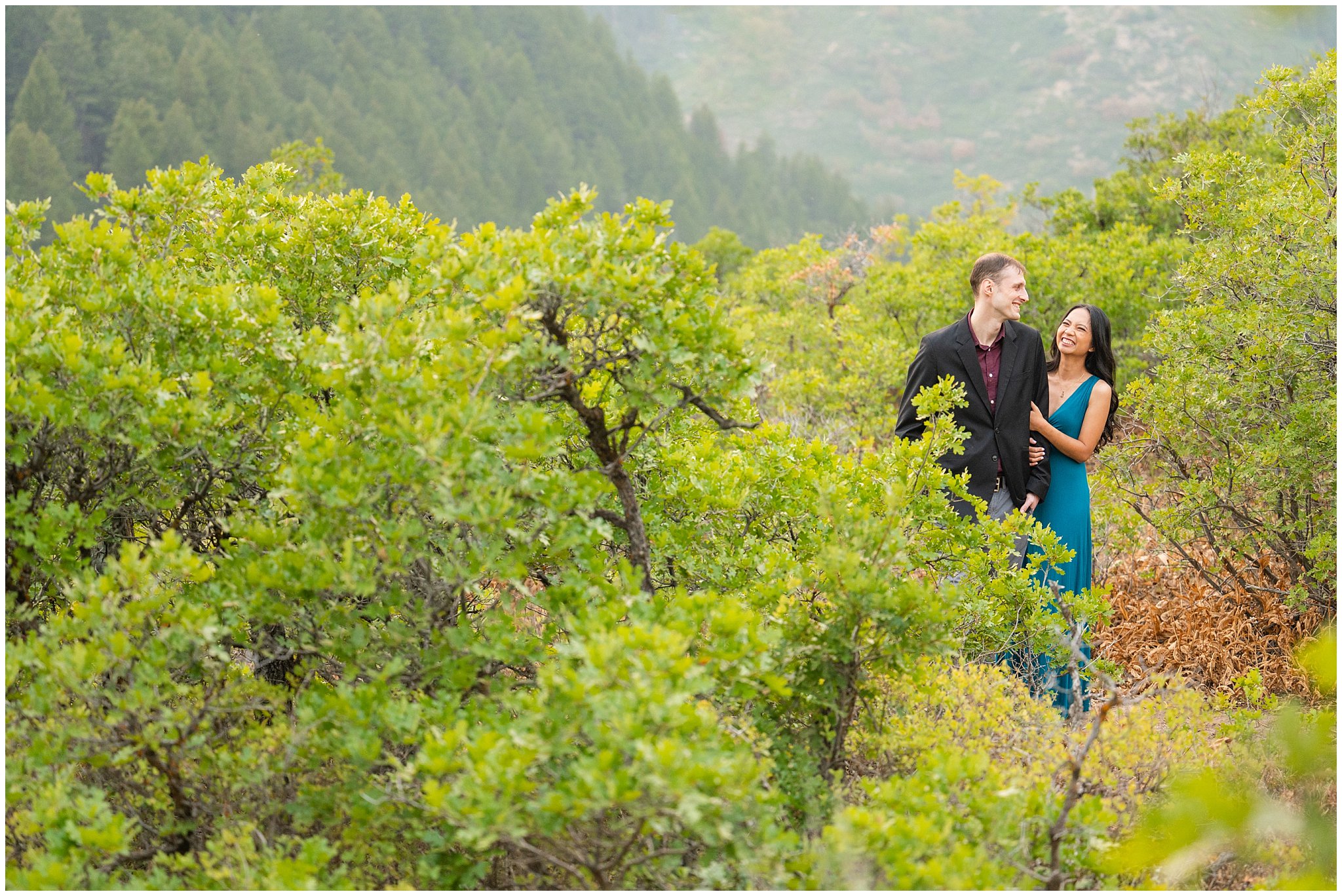 Couple dressed up in formal attire and laughing in the mountains | Summer Utah Mountain Engagement | Jessie and Dallin Photography