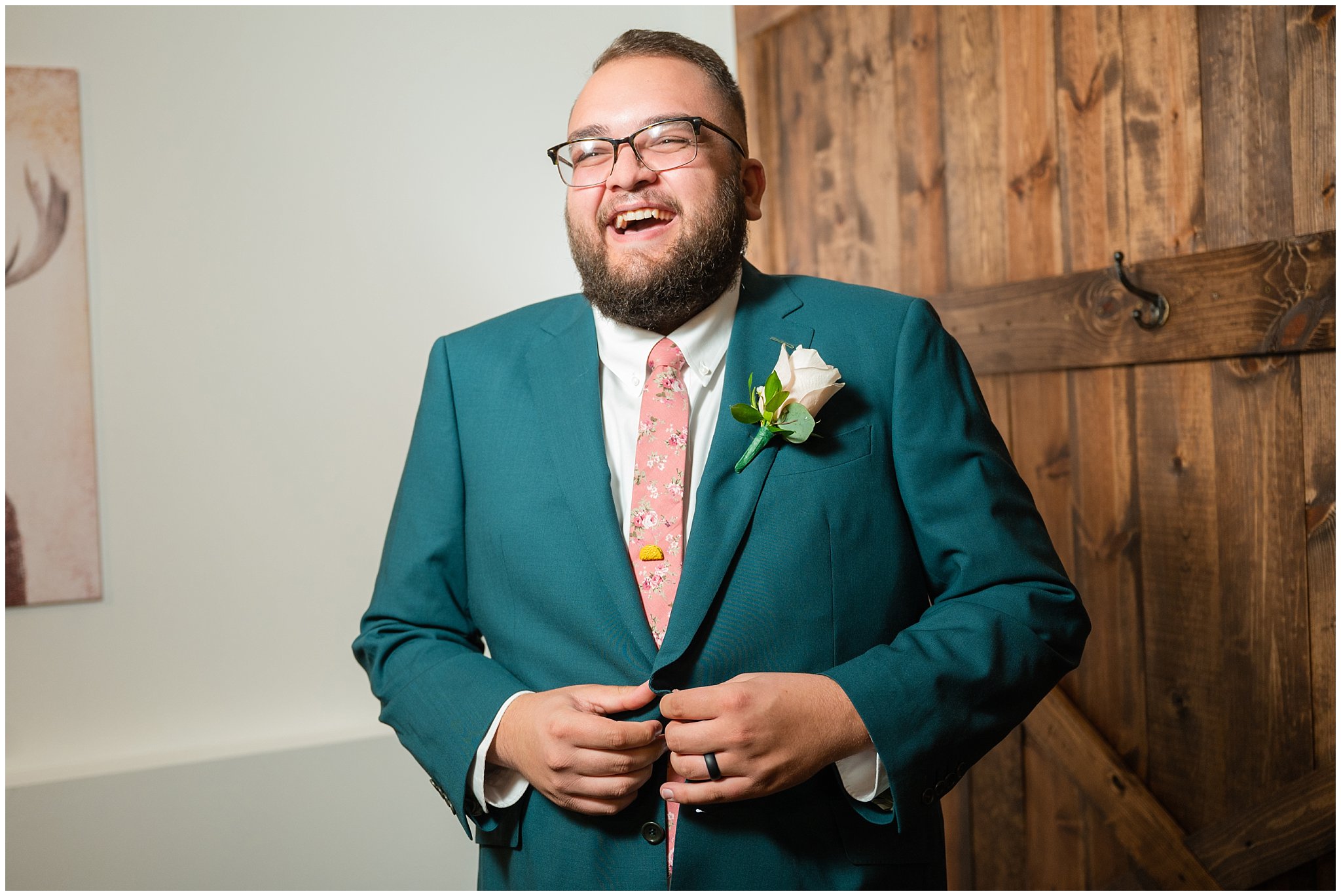 Groom getting ready with green suit, pink tie, and taco pin | Green and Salmon Pink Utah Wedding | Oak Hills | Jessie and Dallin Photography