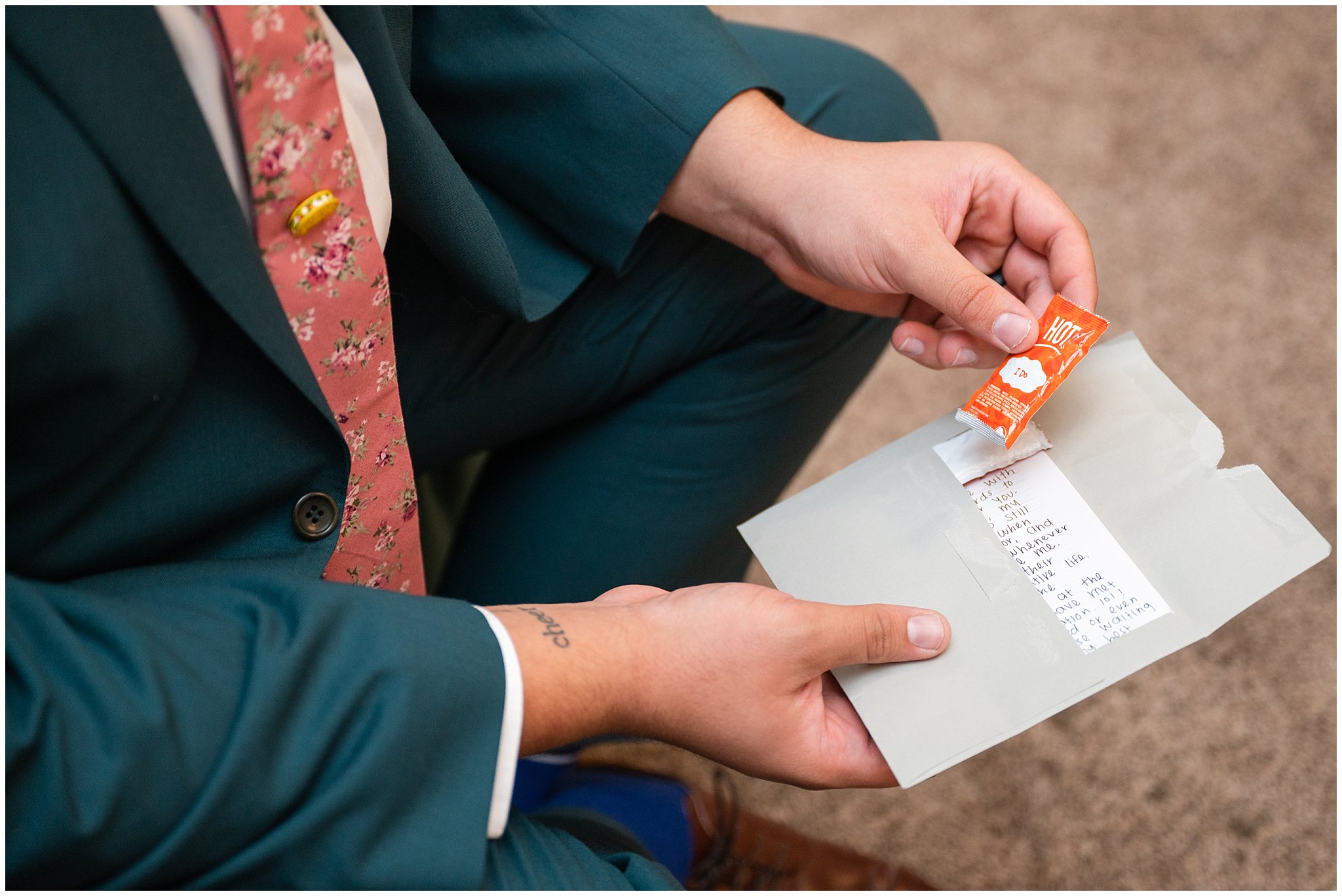 Groom getting ready with green suit, pink tie, and taco pin, and taco bell sauces | Green and Salmon Pink Utah Wedding | Oak Hills | Jessie and Dallin Photography