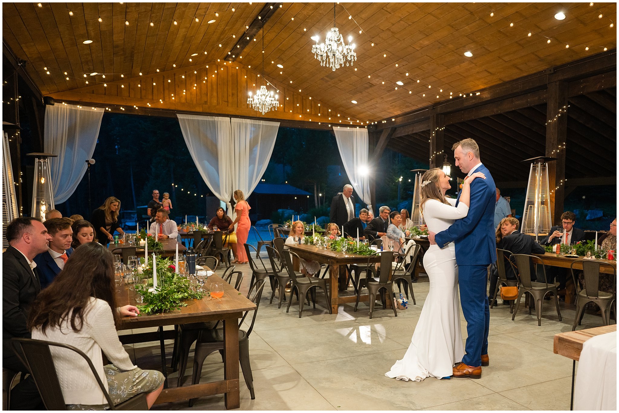 Dancing and reception under pavilion in the forest with draping lights and chandeliers | Mountainside Weddings Kalispell Montana Destination Wedding | Jessie and Dallin Photography