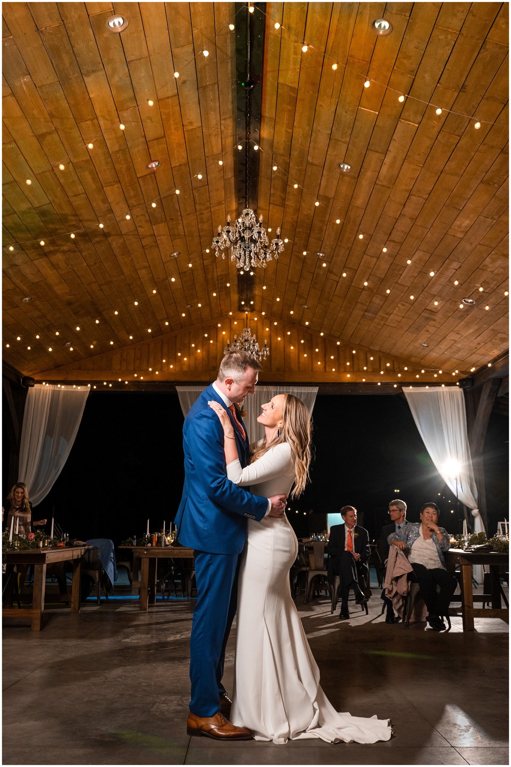 Bride and groom dancing and reception under pavilion in the forest with draping lights and chandeliers | Mountainside Weddings Kalispell Montana Destination Wedding | Jessie and Dallin Photography