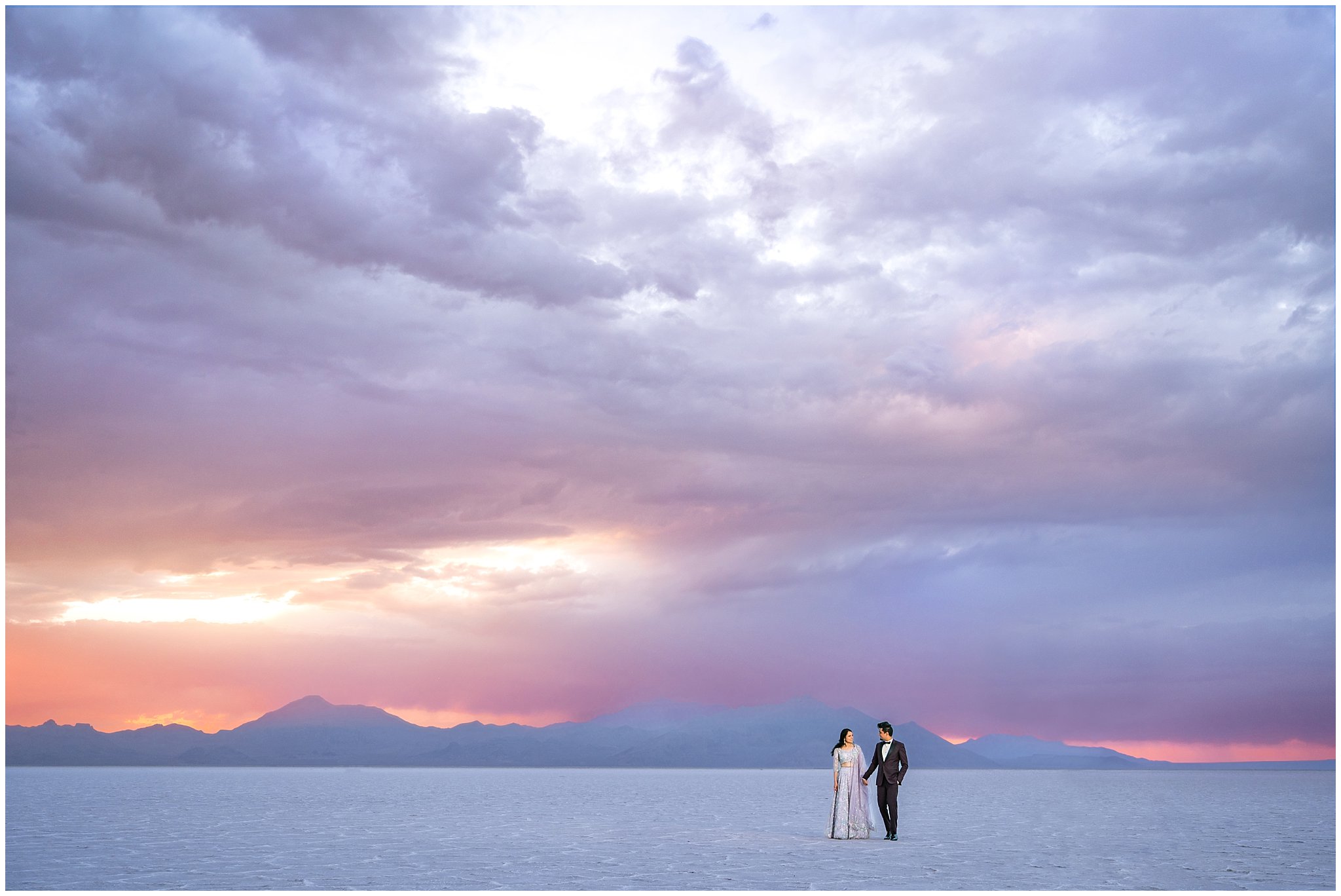 Couple walking at sunset during their Indian wedding session at the Bonneville Salt Flats
