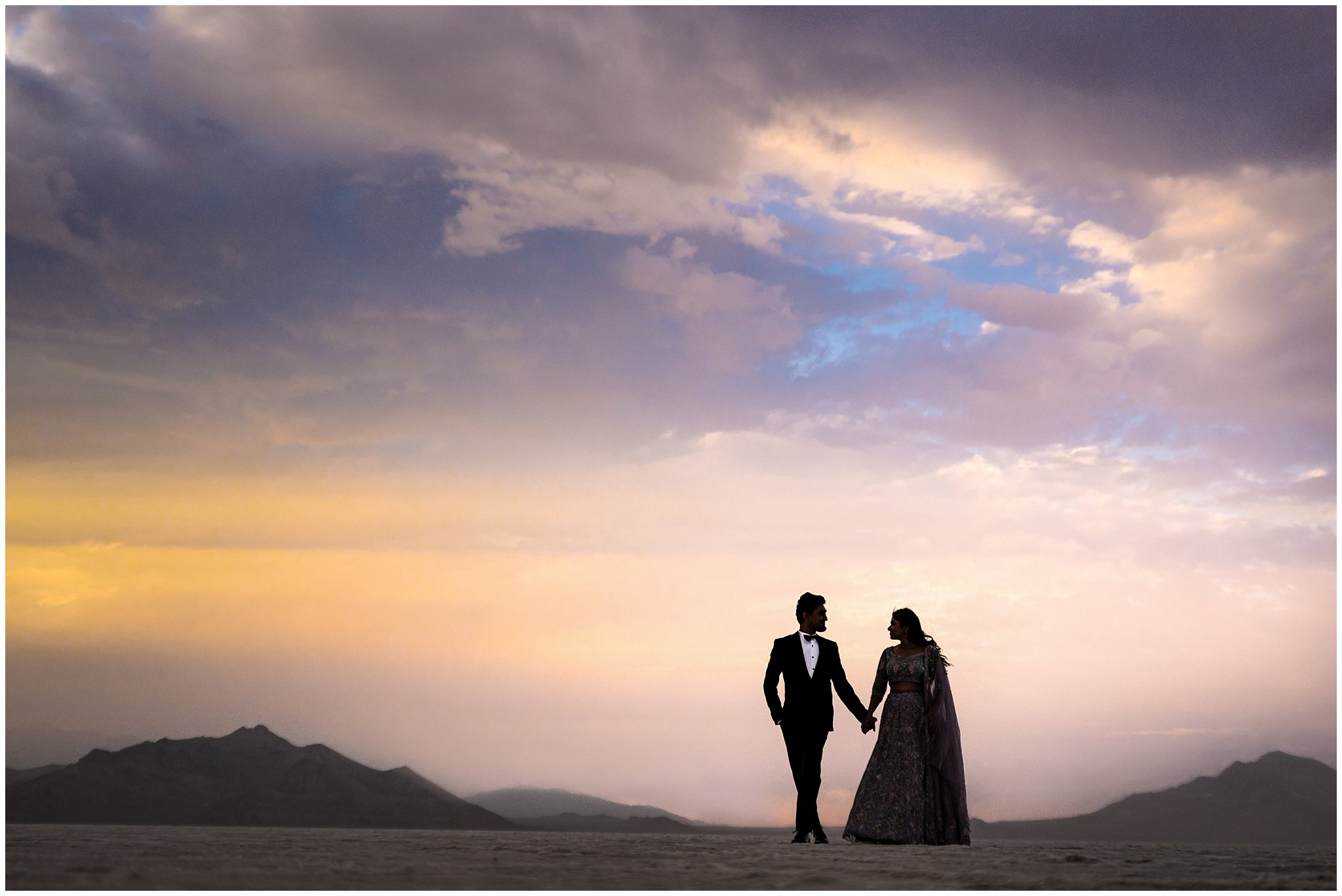 Couple silhouetted walking together during their Indian wedding session at the Bonneville Salt Flats