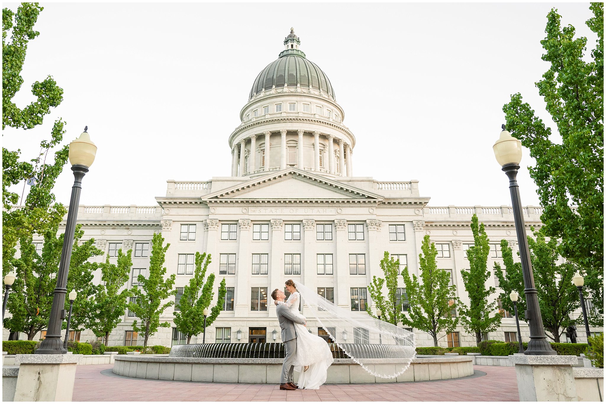 Bride and groom with long cathedral length veil with the Utah State Capitol behind them | Sunset Utah State Capitol Wedding Formal Session | Jessie and Dallin Photography