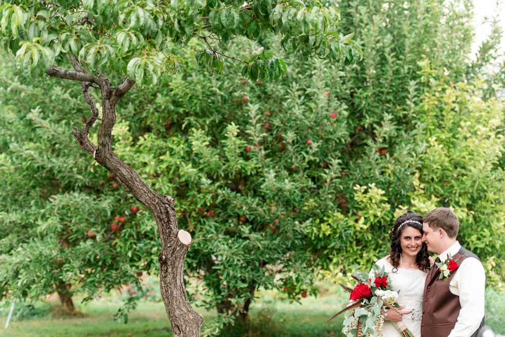 Couple stands by a tree at wedding at the Barker Barn in Ogden Utah