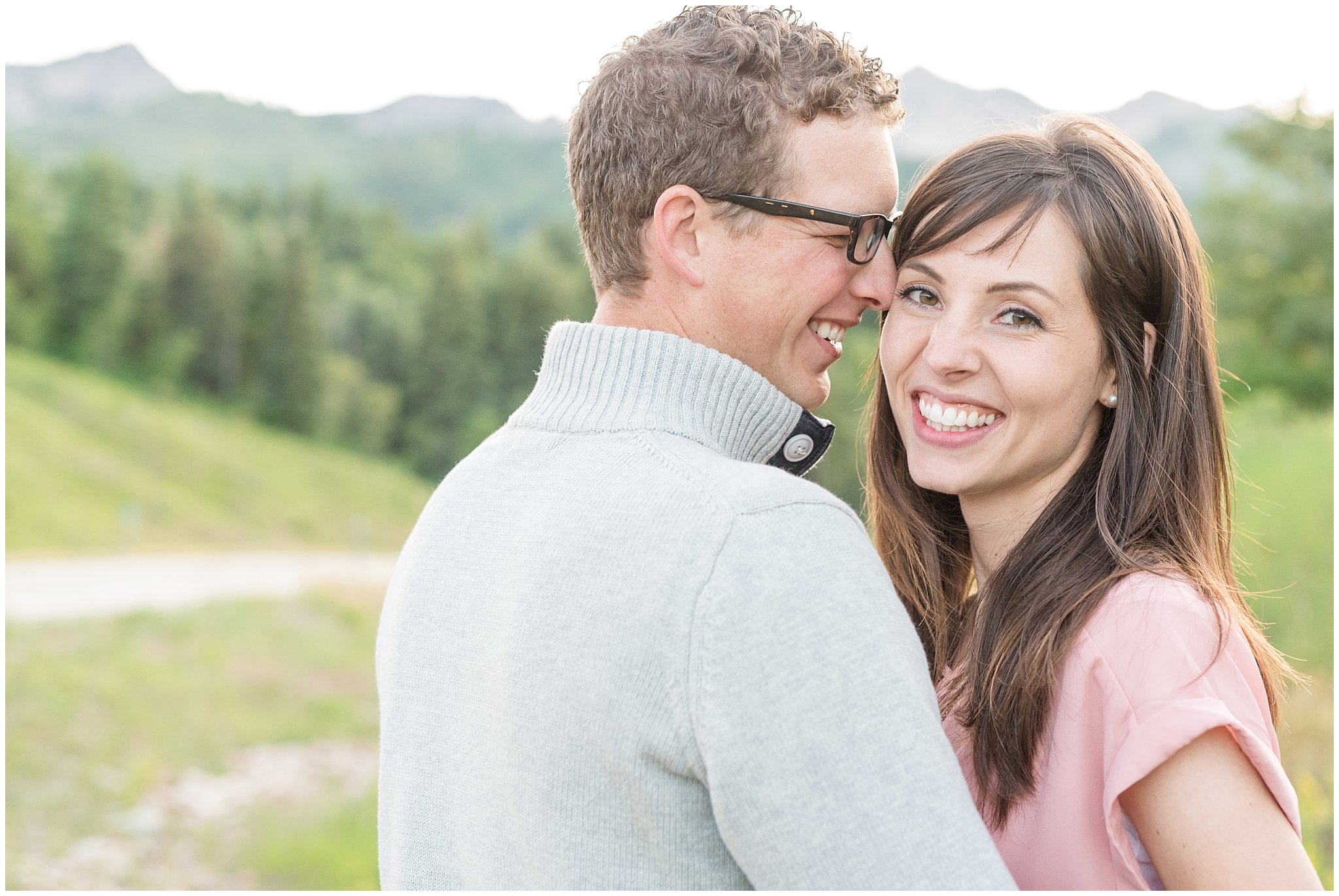 Joyful couple smiling with mountains behind them | Utah couples photography at Snowbasin
