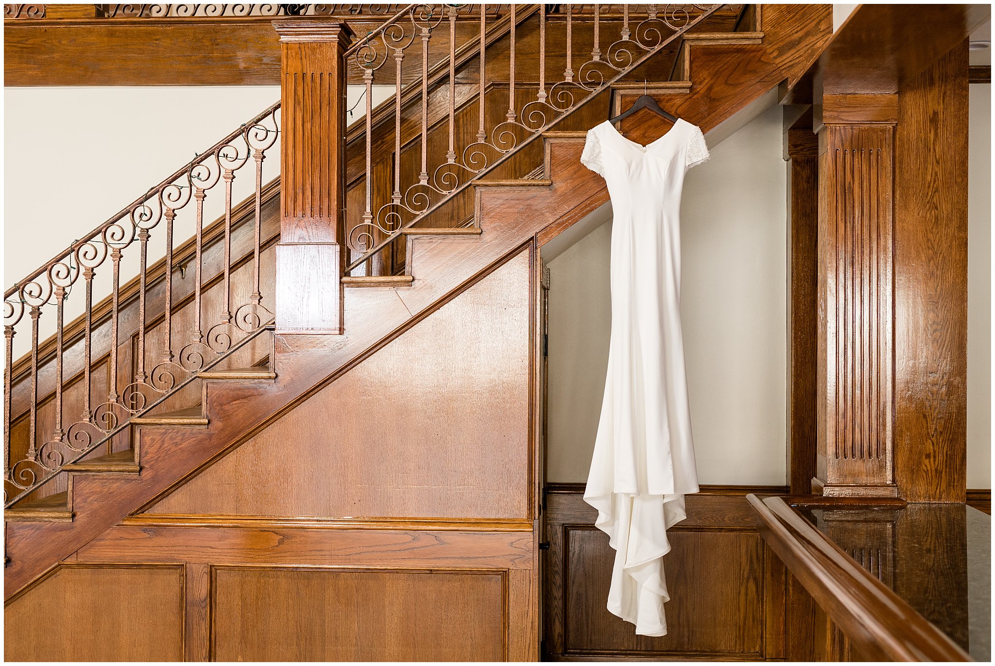 Wedding dress hanging from wooden staircase