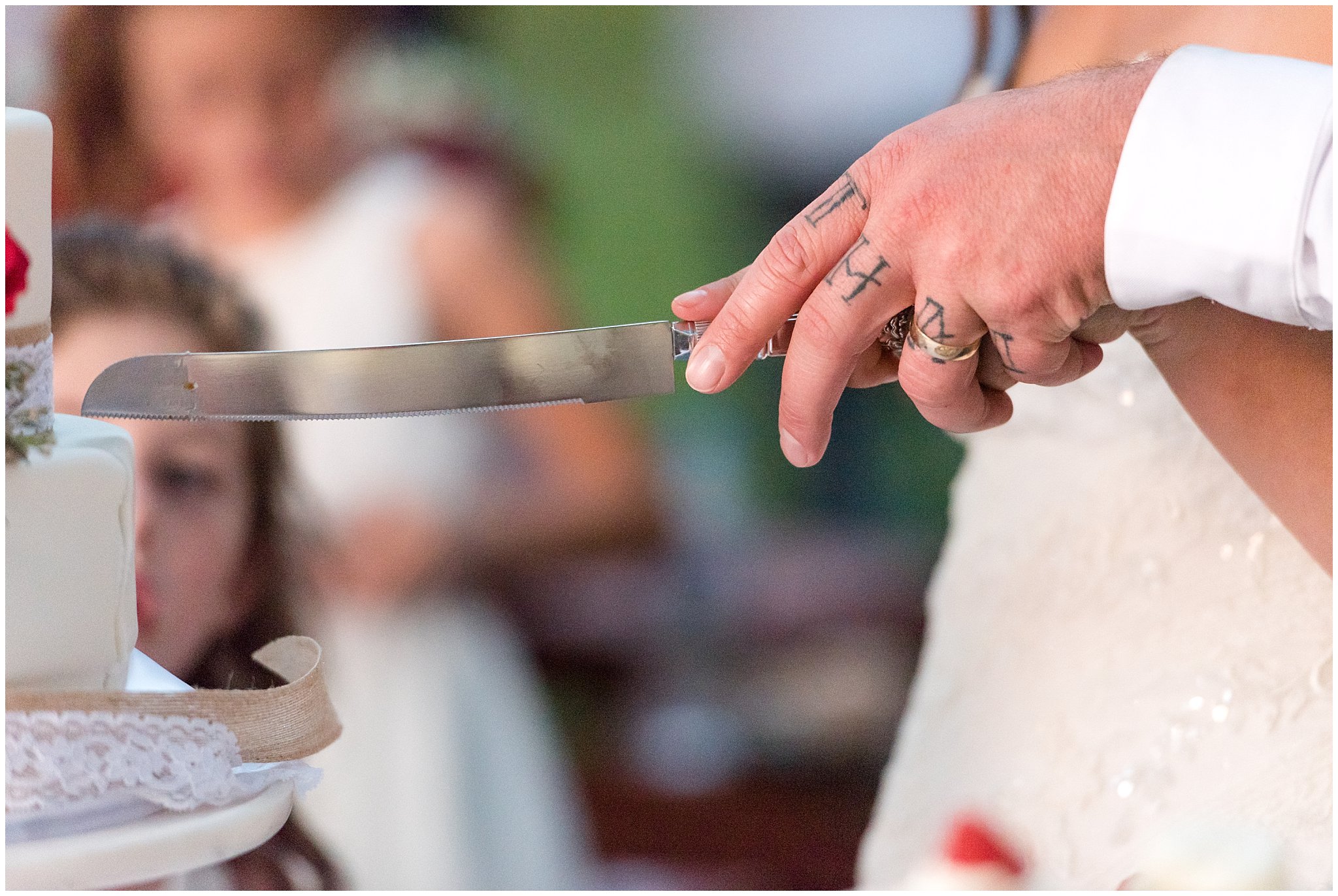 Detail shot of knife and hands while cutting the cake | Red and Grey wedding | Davis County Outdoor Wedding | Jessie and Dallin Photography