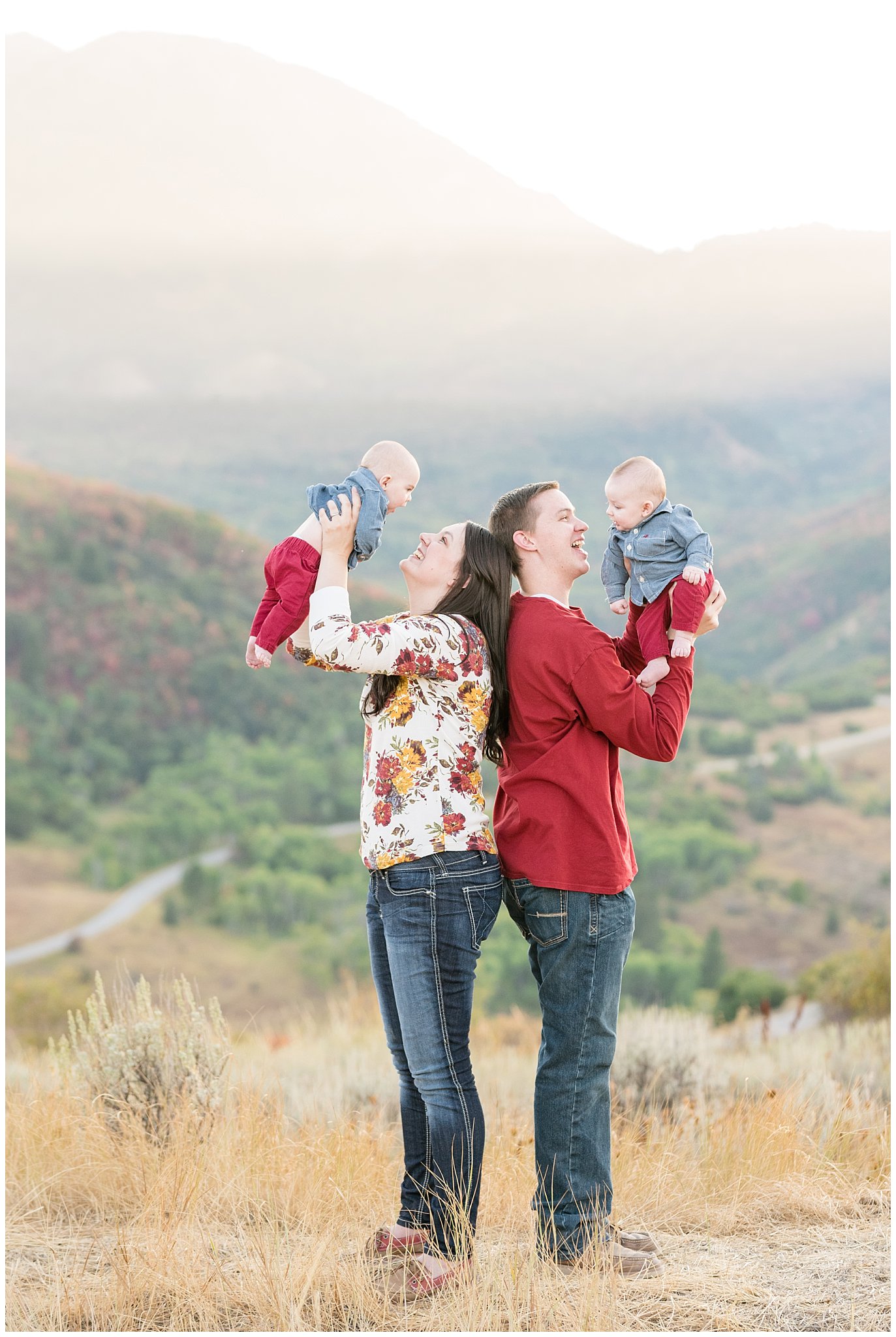 Candid family picture with parents lifting up twin infants | Fall Family Pictures at Snowbasin | Jessie and Dallin Photography