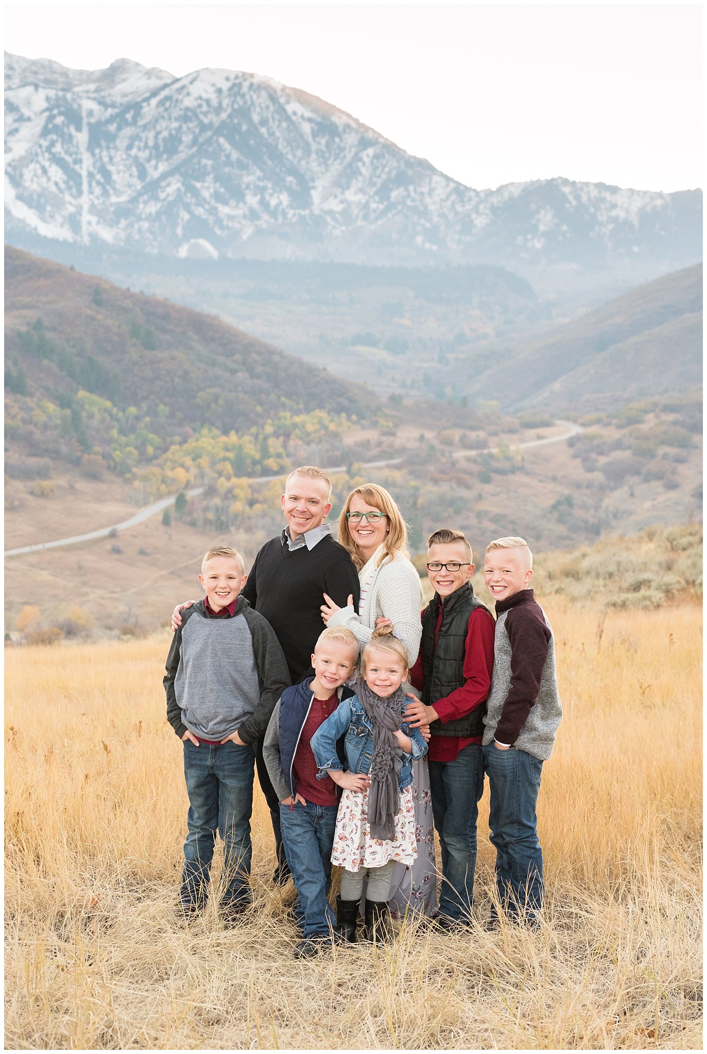 Family of 7 standing in front of snowy mountain peaks | Fall Family Pictures in the Mountains | Snowbasin, Utah | Jessie and Dallin Photography
