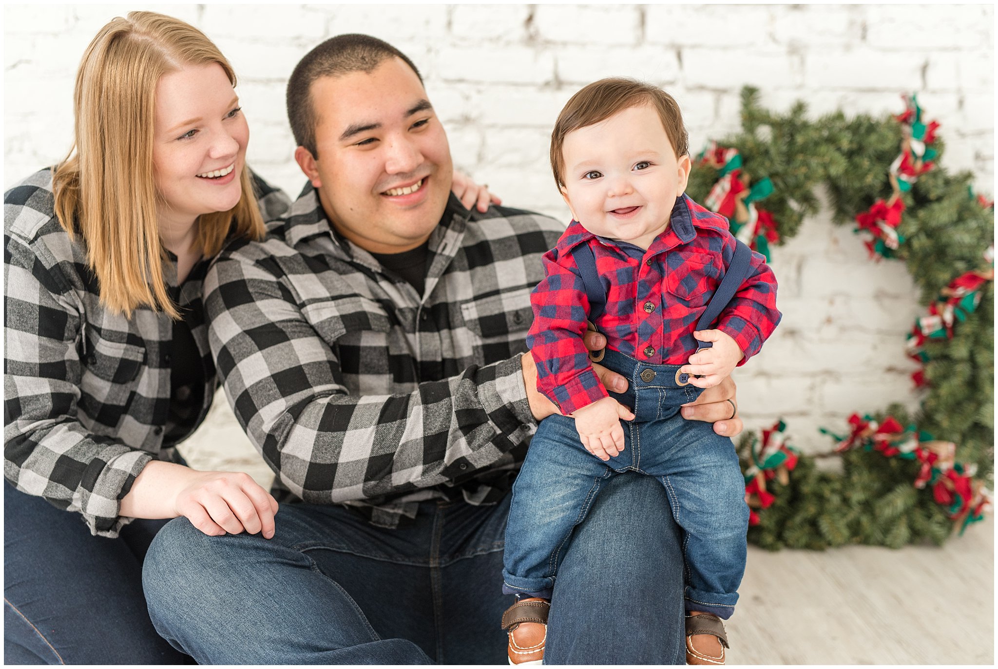 Baby laughing while parents hold him on their knee | Family Christmas session at the 5th floor | Utah Photographers | Jessie and Dallin Photography