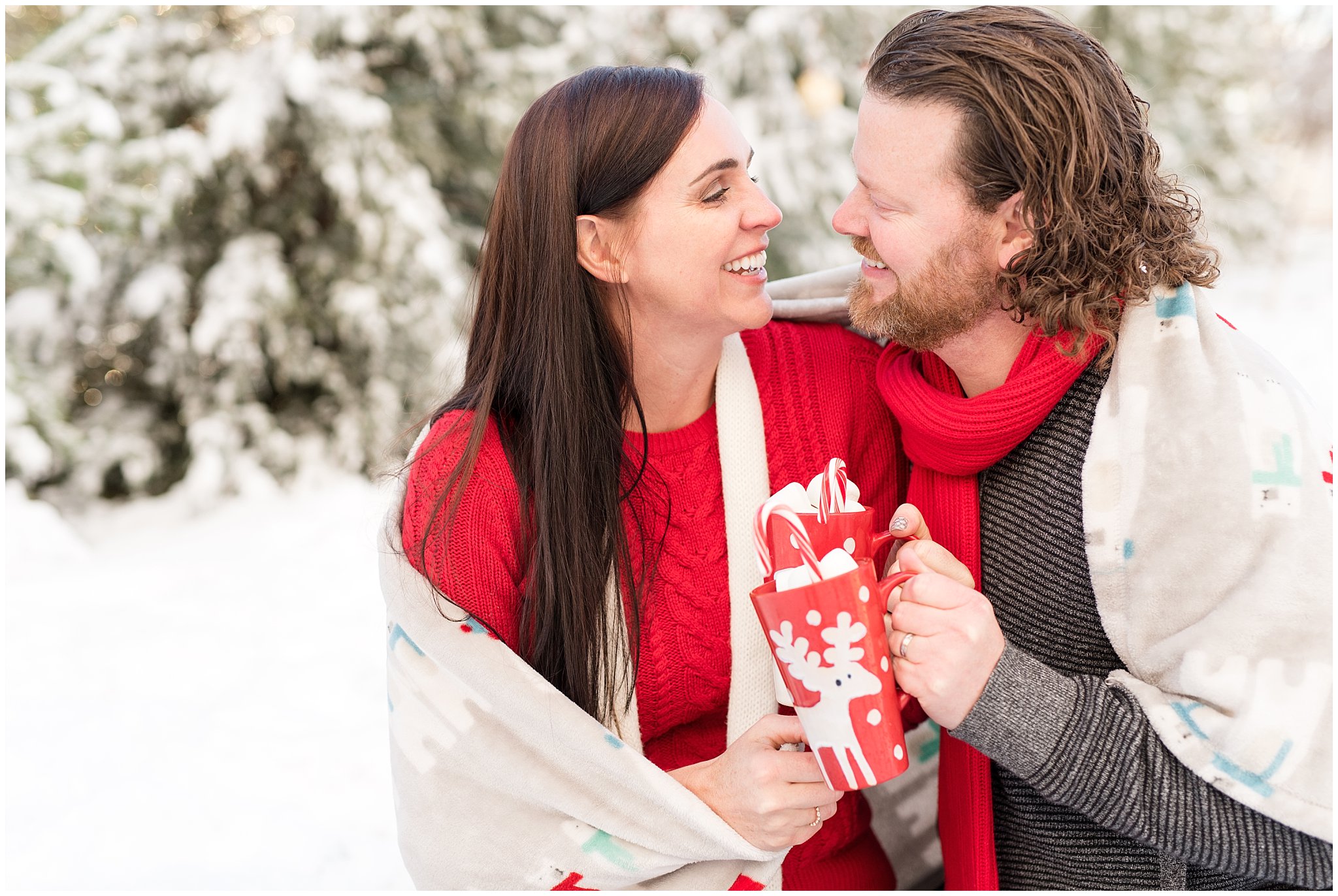 Couple cuddled up with blanket and hot chocolate in the snow | Utah Family Christmas Photoshoot | Oak Hills Reception and Event | Jessie and Dallin Photography