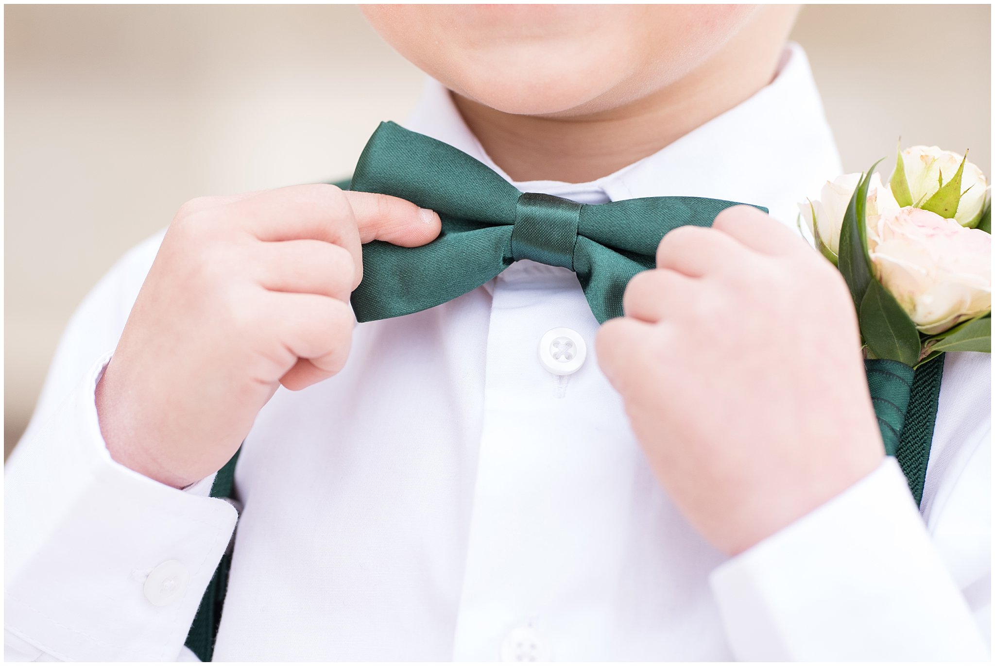 Ring bearer adjusting green bowtie | Ogden Temple Winter Wedding | Emerald Green and Pink Wedding | Jessie and Dallin Photography
