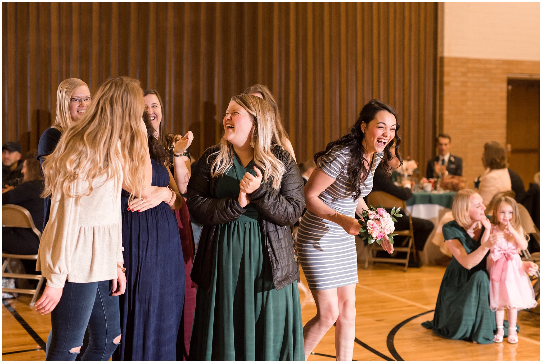 Wedding guest catches bouquet toss excitedly | Ogden Temple Winter Wedding | Emerald Green and Pink Wedding | Jessie and Dallin Photography
