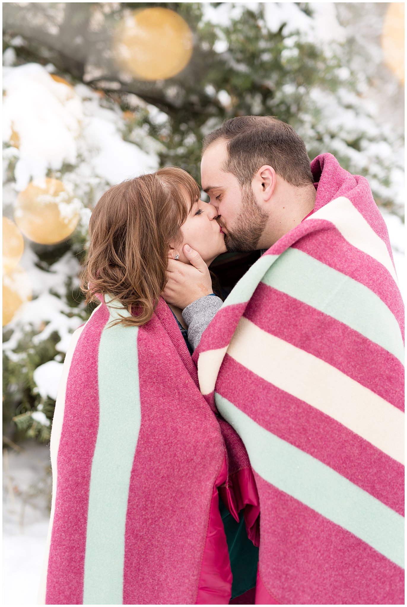 Couple kissing wrapped in blanket in the forest |  Winter Engagement at Mueller Park and the Utah State Capitol | Jessie and Dallin Photography
