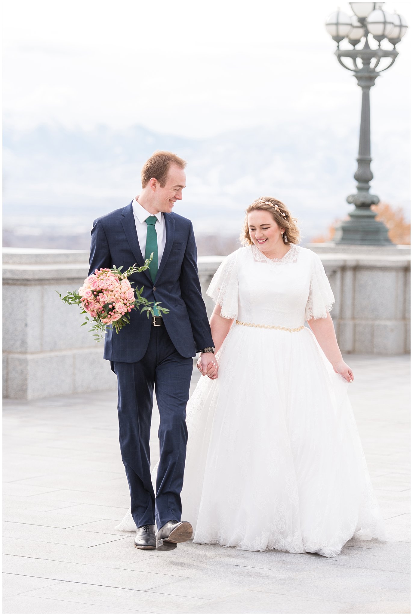Bride and groom laugh and walk while groom holds bouquet | Winter Formals at the Utah State Capitol | Utah Wedding Photography