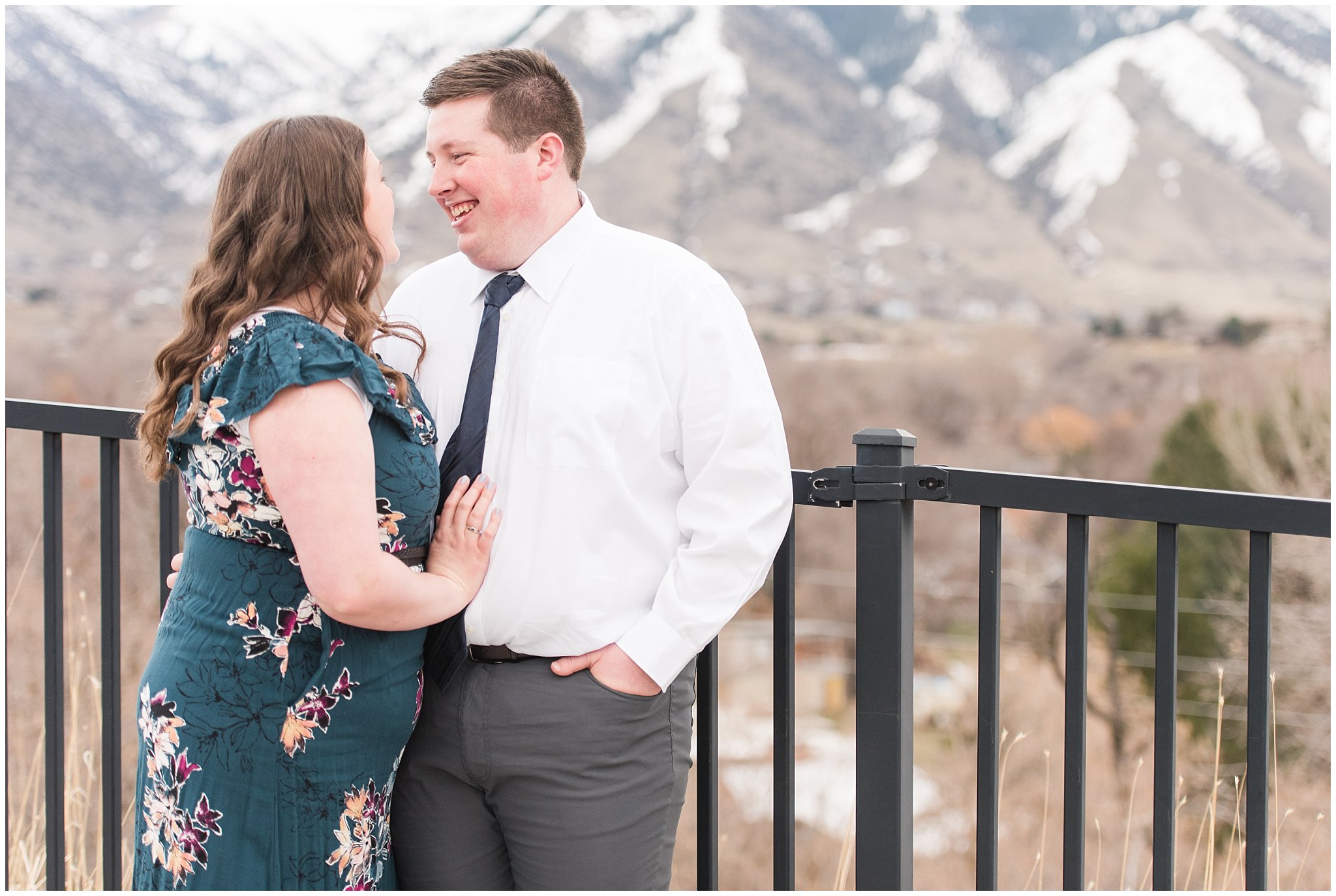 Couple dressed up in white shirt and tie and green blue floral dress by the mountains | Downtown Logan and Green Canyon Engagements | Utah Wedding Photographers | Jessie and Dallin Photography