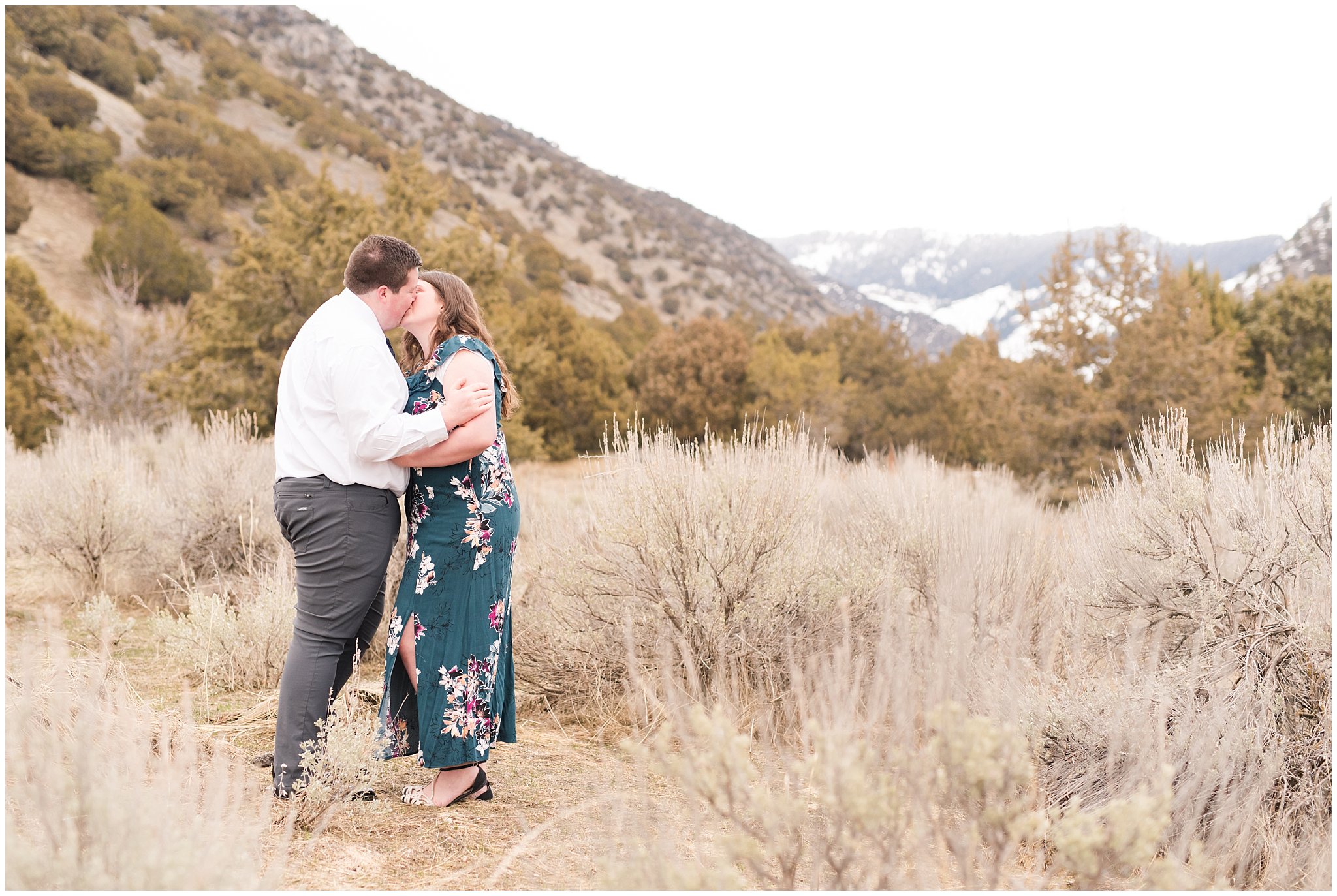 Couple dressed up in white shirt and tie and green blue floral dress by the mountains | Downtown Logan and Green Canyon Engagements | Utah Wedding Photographers | Jessie and Dallin Photography