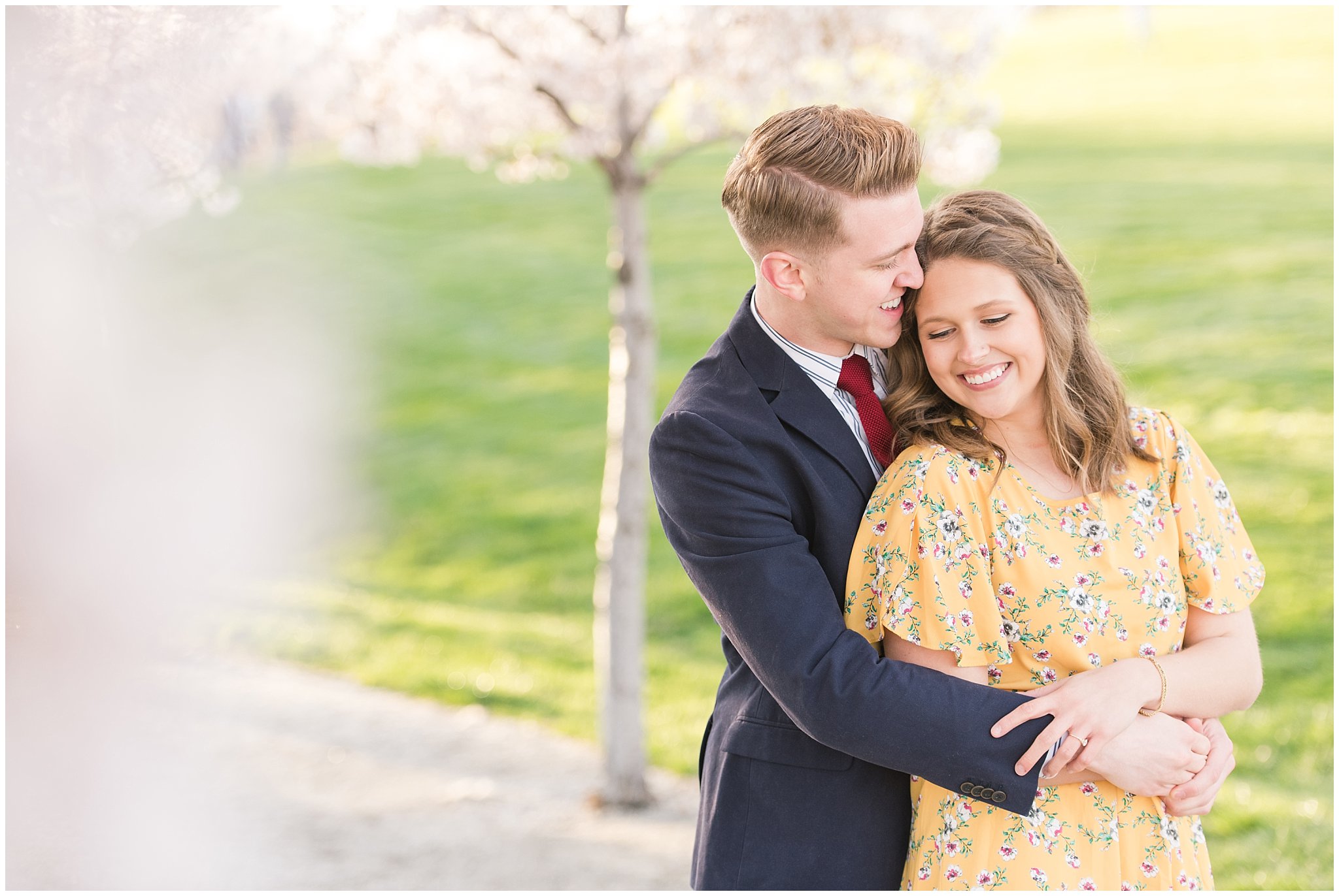 Couple dressed up in suit and yellow dress in the cherry blossoms | Spring Blossom Engagement at the Utah State Capitol | Utah Wedding Photographers | Jessie and Dallin