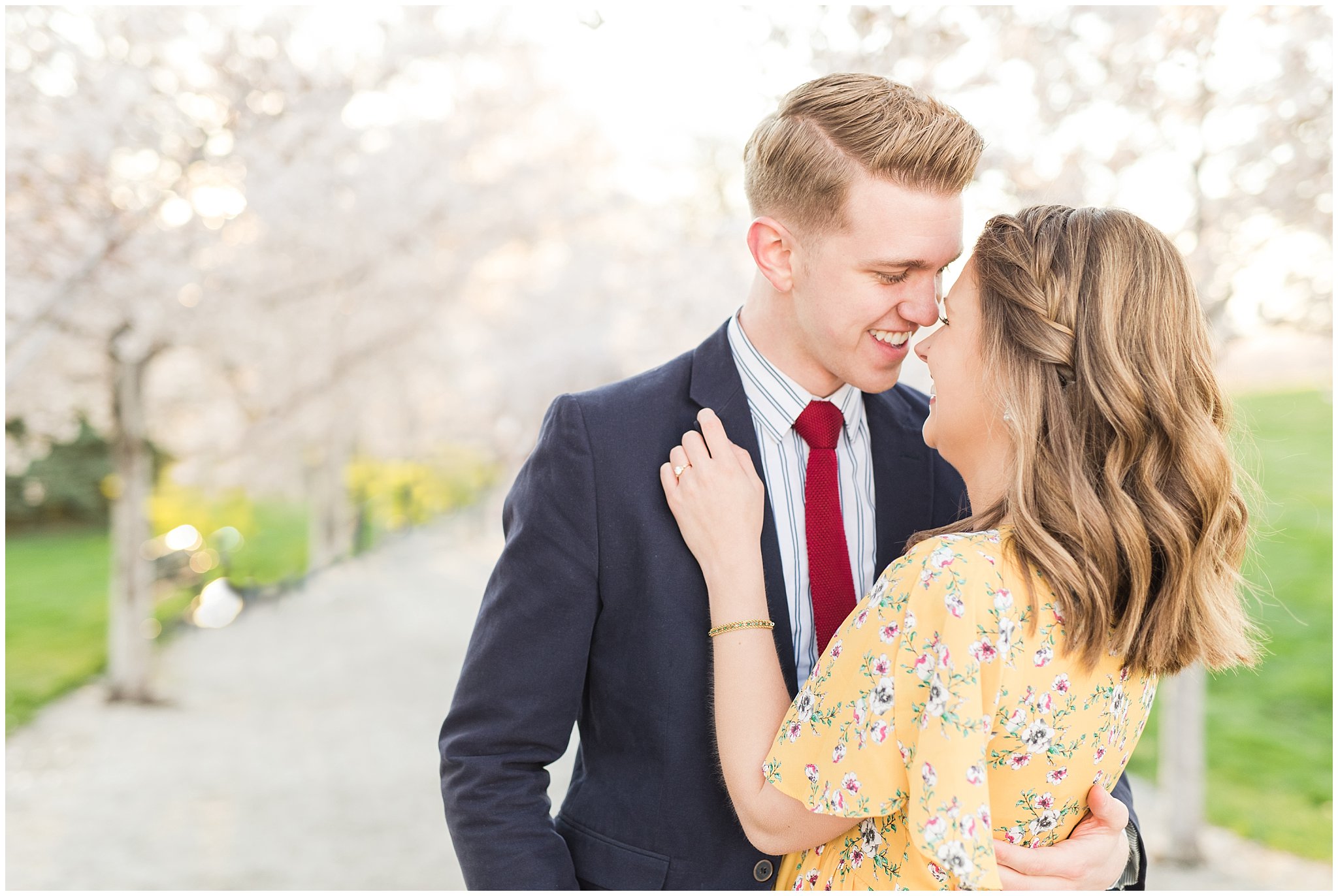 Couple dressed up in suit and yellow dress in the cherry blossoms | Spring Blossom Engagement at the Utah State Capitol | Utah Wedding Photographers | Jessie and Dallin