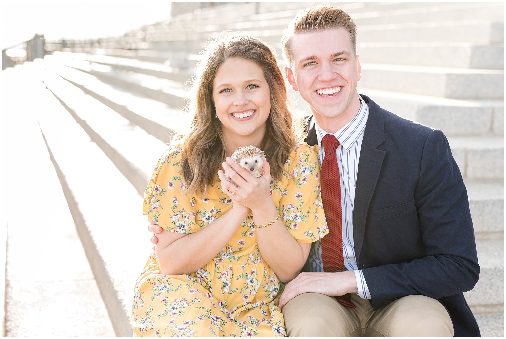 Couple holding hedgehog and dressed up in suit and yellow dress in the cherry blossoms | Spring Blossom Engagement at the Utah State Capitol | Utah Wedding Photographers | Jessie and Dallin