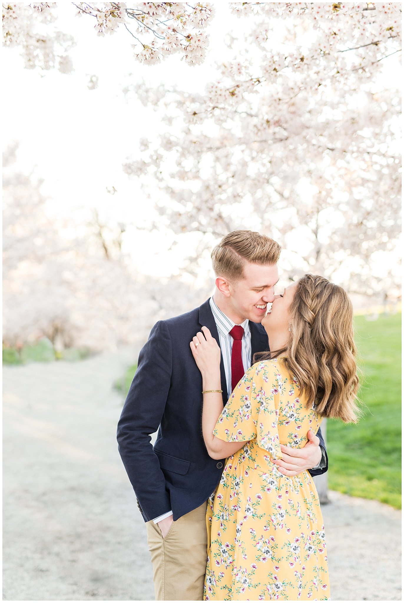 Couple dressed up in suit and yellow dress in the cherry blossoms | Spring Blossom Engagement at the Utah State Capitol | Utah Wedding Photographers | Jessie and Dallin