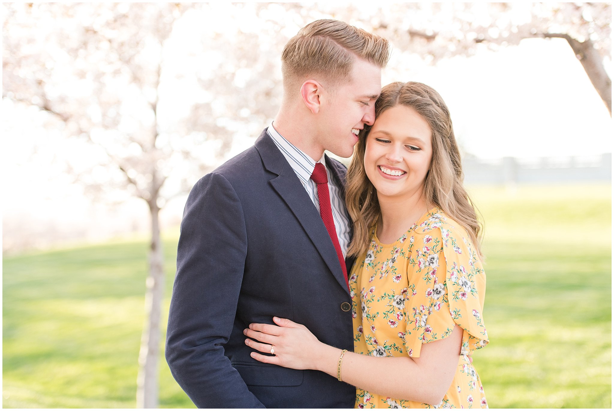 Couple dressed up in suit and yellow dress in the cherry blossoms | Spring Blossom Engagement at the Utah State Capitol | Utah Wedding Photographers | Jessie and Dallin