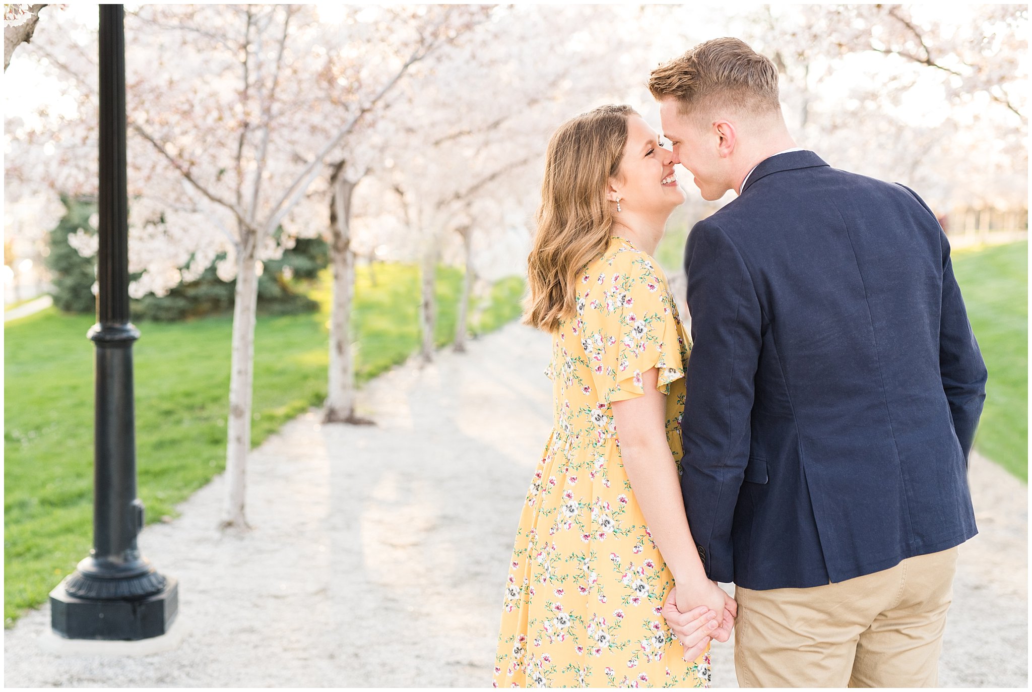 Couple dressed up in suit and yellow dress in the cherry blossoms | Spring Blossom Engagement at the Utah State Capitol | Utah Wedding Photographers | Jessie and Dallin