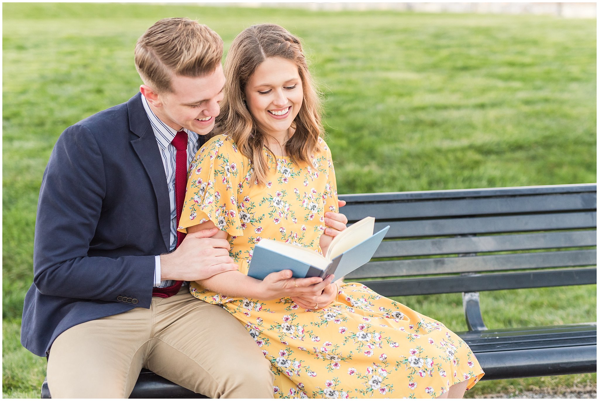 Couple reading a book and dressed up in suit and yellow dress in the cherry blossoms | Spring Blossom Engagement at the Utah State Capitol | Utah Wedding Photographers | Jessie and Dallin