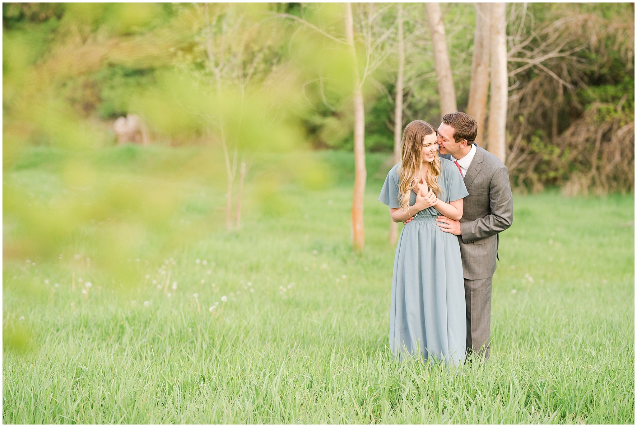 Couple dressed up in flowy blue dress and grey suit for engagement in the woods | Utah Engagement | Jessie and Dallin Photography