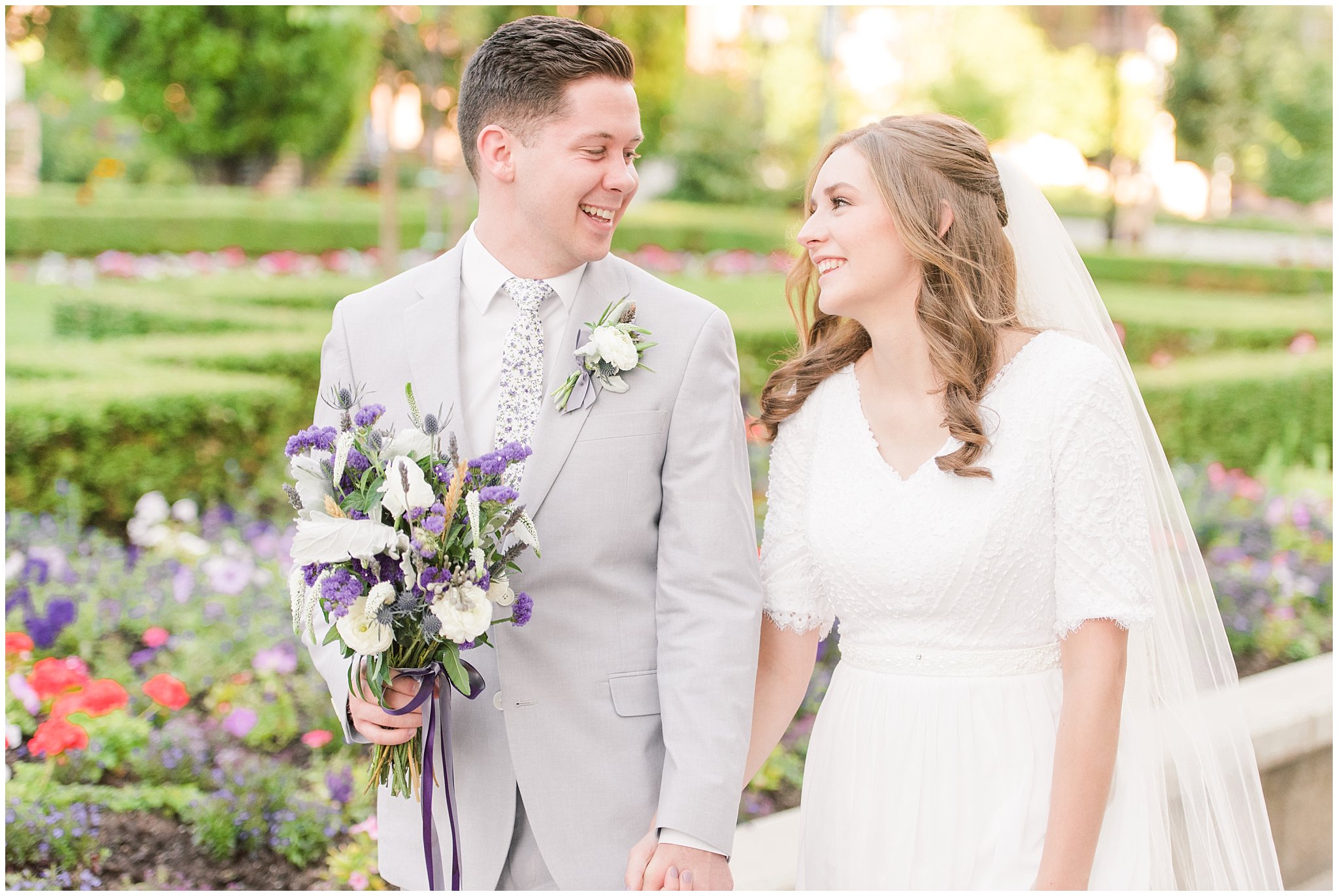 Bride and groom wearing elegant, simple dress with veil and grey suit with lavender florals | Elegant formal session at the Salt Lake Temple and Ensign Peak Formal Session | Jessie and Dallin Photography