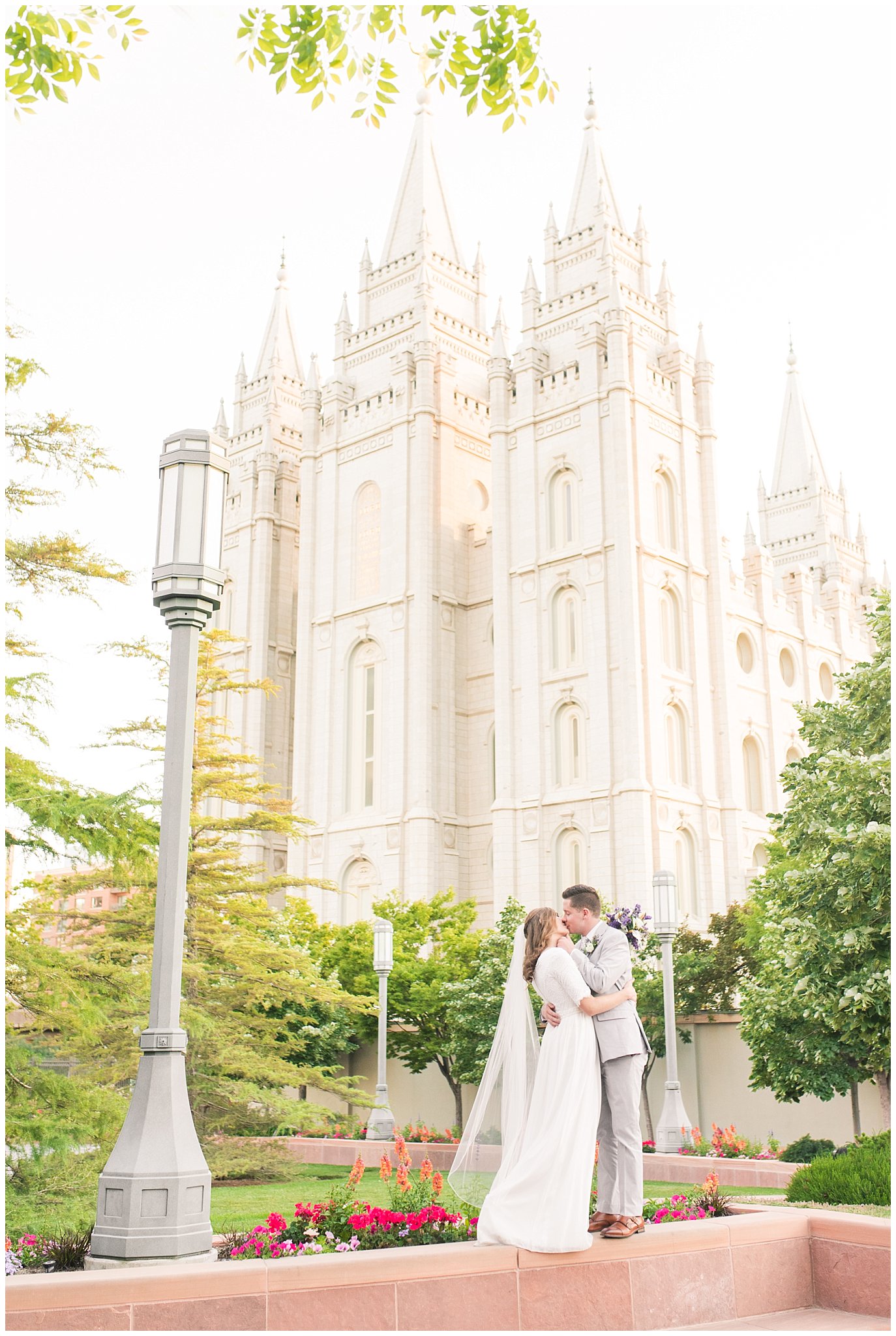 Bride and groom wearing elegant, simple dress with veil and grey suit with lavender florals | Elegant formal session at the Salt Lake Temple and Ensign Peak Formal Session | Jessie and Dallin Photography