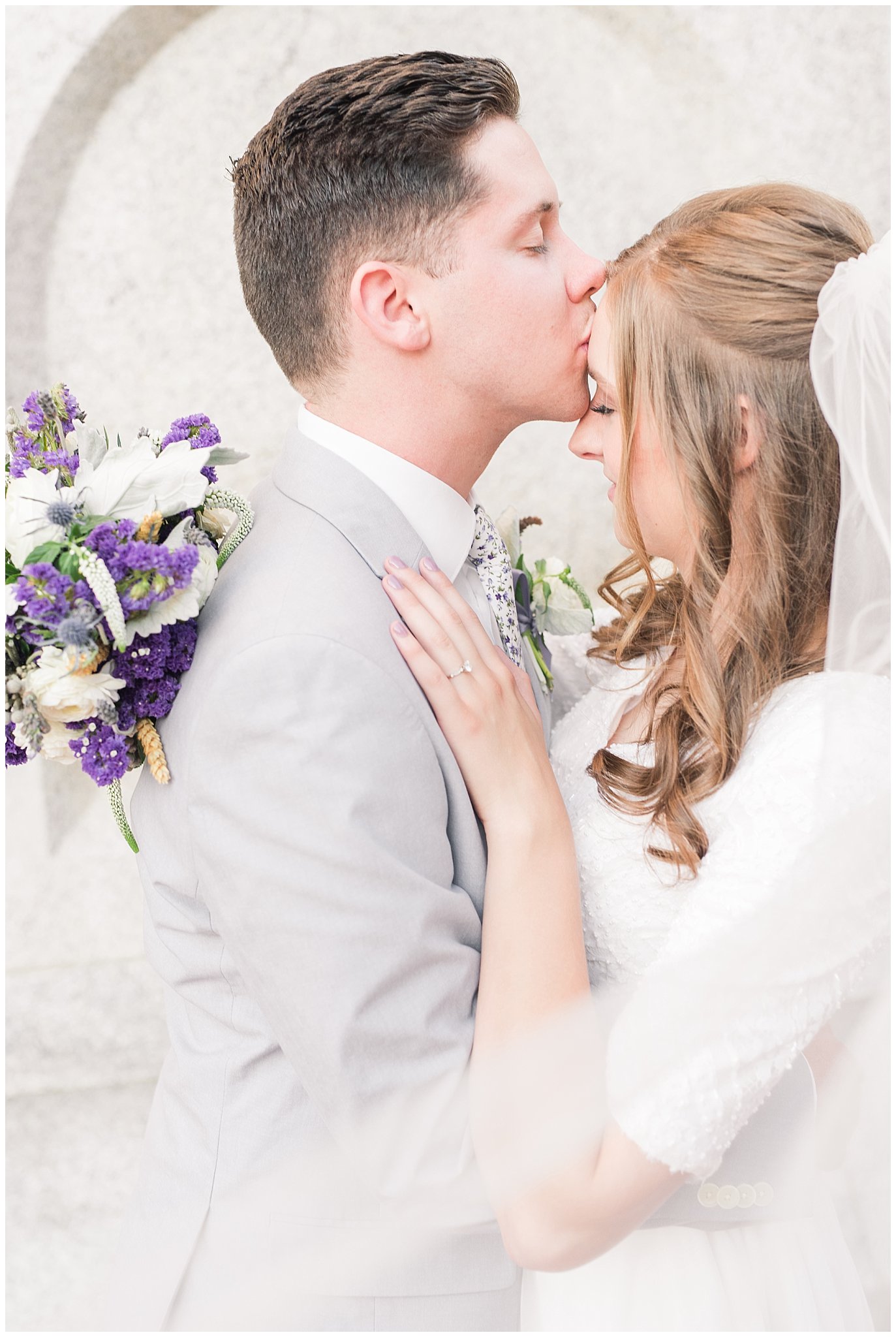 Bride and groom wearing elegant, simple dress with veil and grey suit with lavender florals | Elegant formal session at the Salt Lake Temple and Ensign Peak Formal Session | Jessie and Dallin Photography