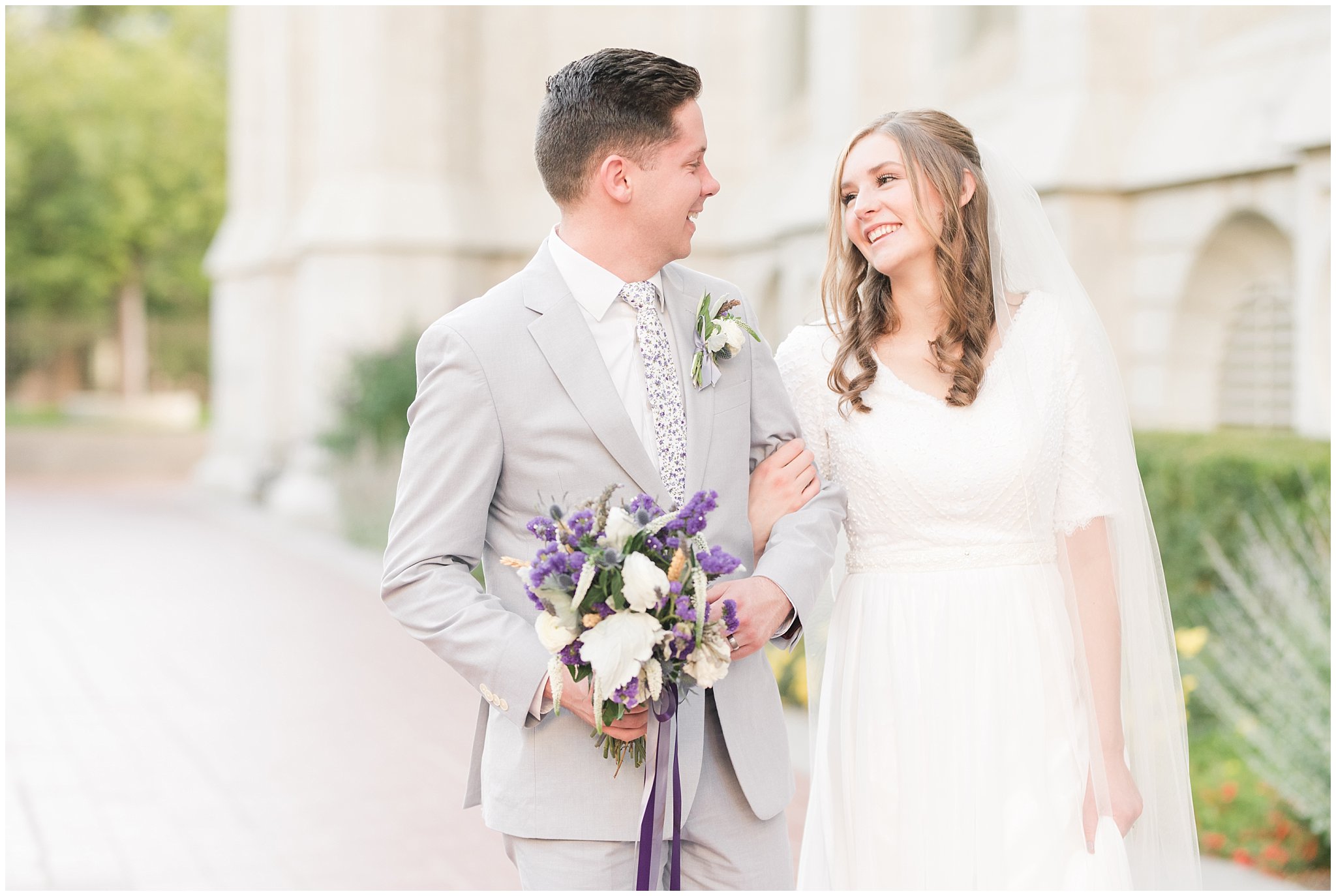 Bride and groom wearing elegant, simple dress with veil and grey suit with lavender florals | Elegant formal session at the Salt Lake Temple and Ensign Peak Formal Session | Jessie and Dallin Photography