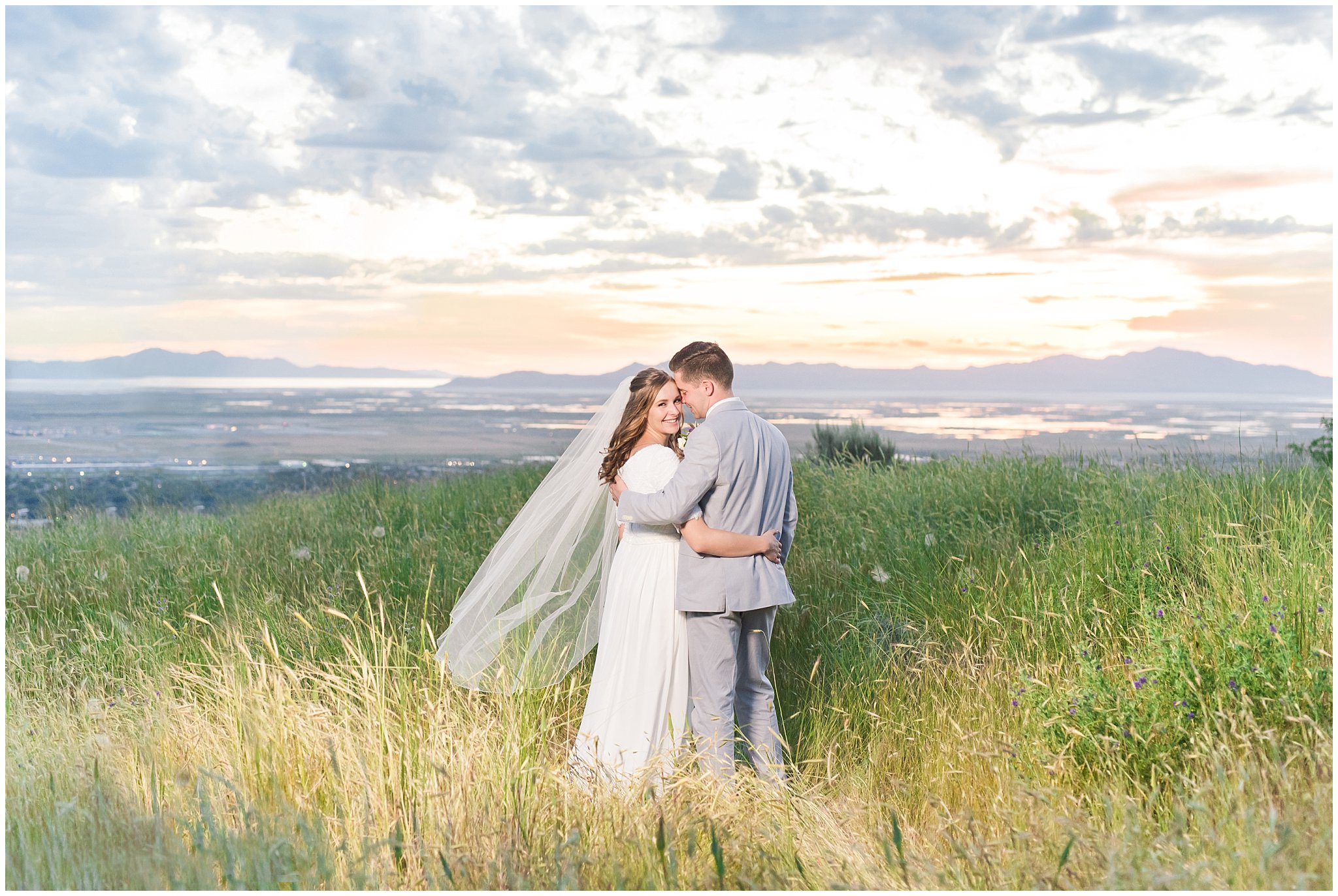 Bride and groom at sunset overlooking Salt Lake City | Wearing elegant, simple dress with veil and grey suit with lavender florals | Elegant formal session at the Salt Lake Temple and Ensign Peak Formal Session | Jessie and Dallin Photography