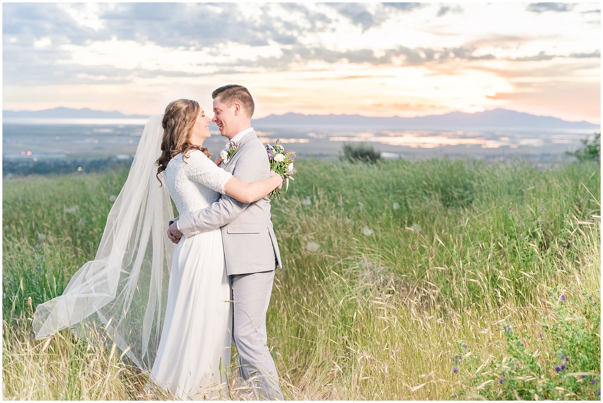 Bride and groom at sunset overlooking Salt Lake City | Wearing elegant, simple dress with veil and grey suit with lavender florals | Elegant formal session at the Salt Lake Temple and Ensign Peak Formal Session | Jessie and Dallin Photography