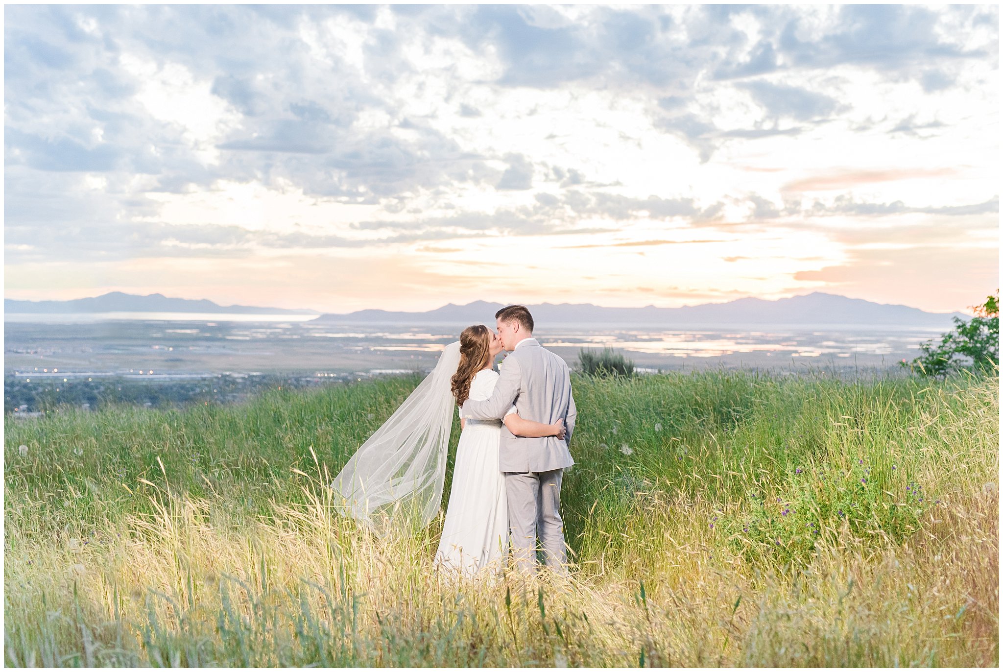 Bride and groom at sunset overlooking Salt Lake City | Wearing elegant, simple dress with veil and grey suit with lavender florals | Elegant formal session at the Salt Lake Temple and Ensign Peak Formal Session | Jessie and Dallin Photography