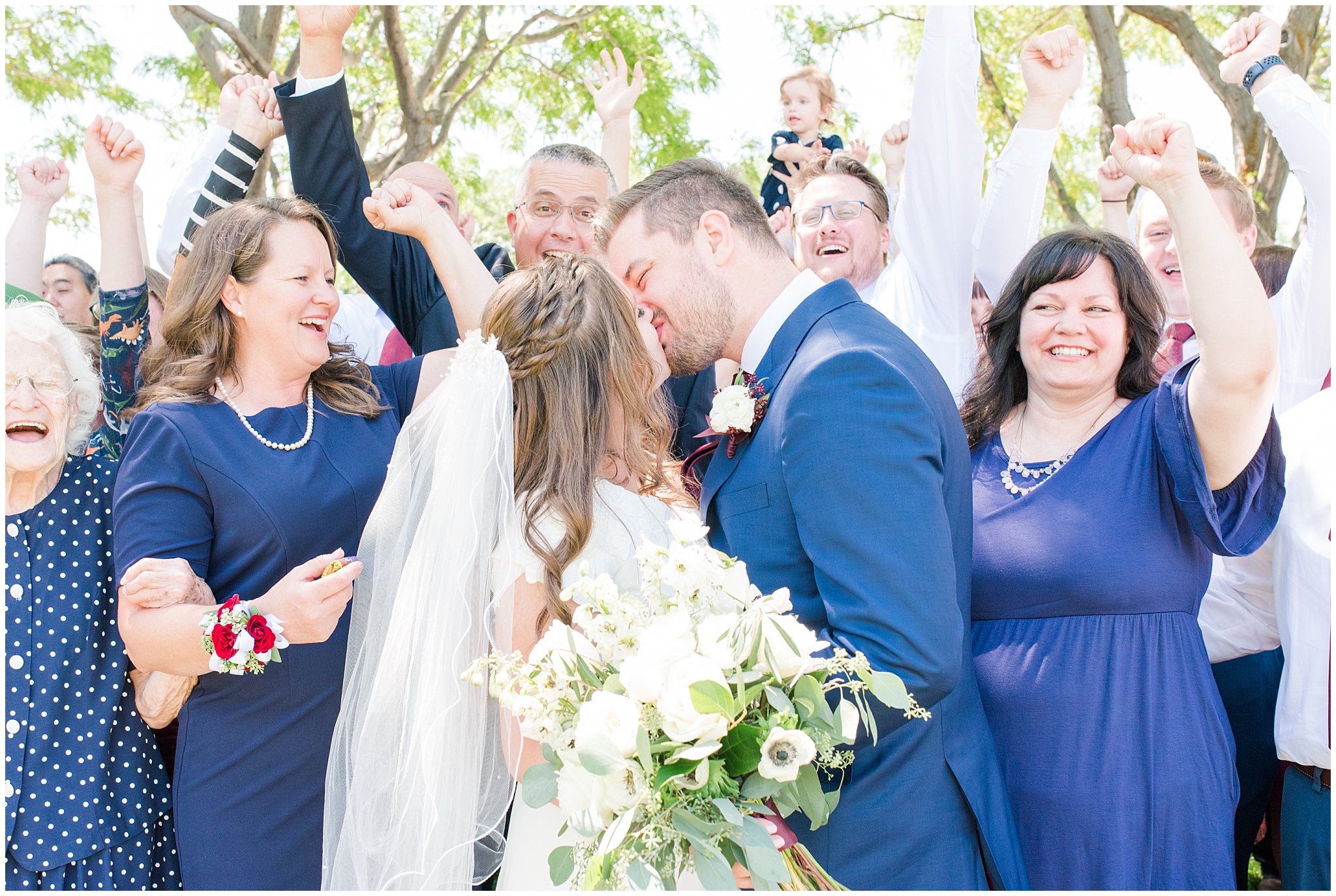 Bride and groom kiss during family Portraits after temple wedding | Summer Bountiful Temple Wedding | Jessie and Dallin Photography