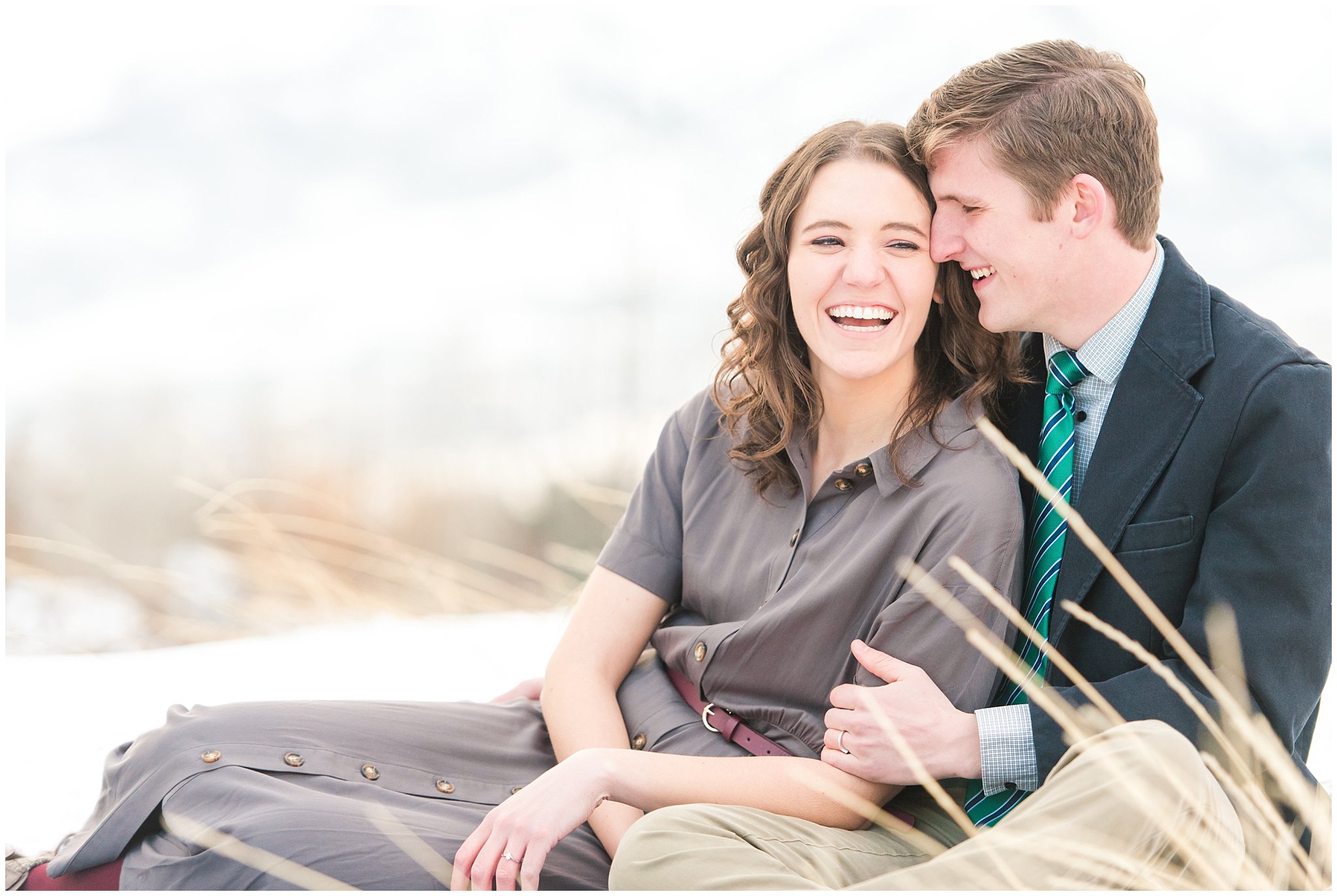 Snowy engagement session with couple dressed up in grey dress and navy sport coat in the mountains | Snowbasin Winter Engagement Session