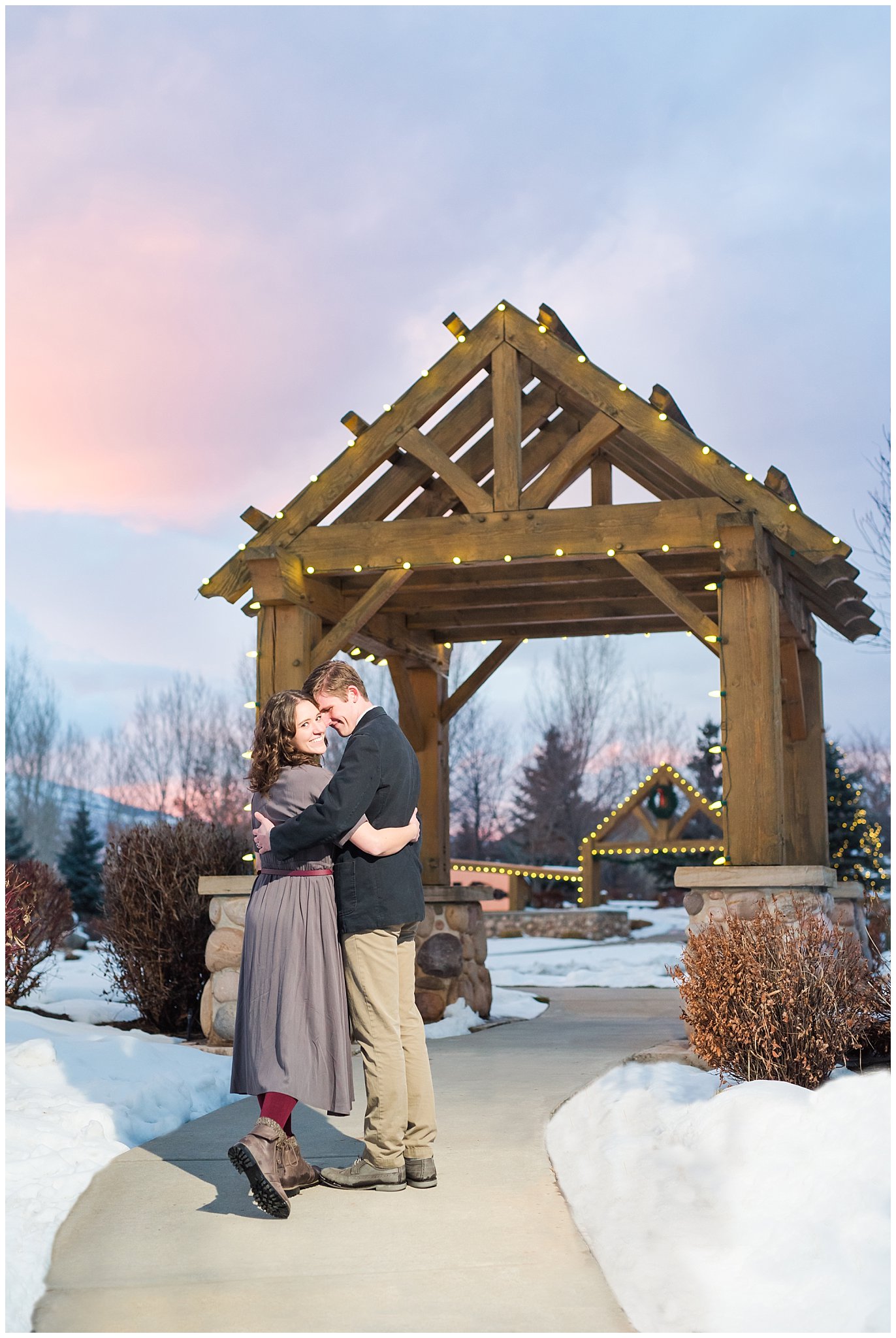 Snowy sunset engagement session with couple dressed up in grey dress and navy sport coat in the mountains | Snowbasin Winter Engagement Session