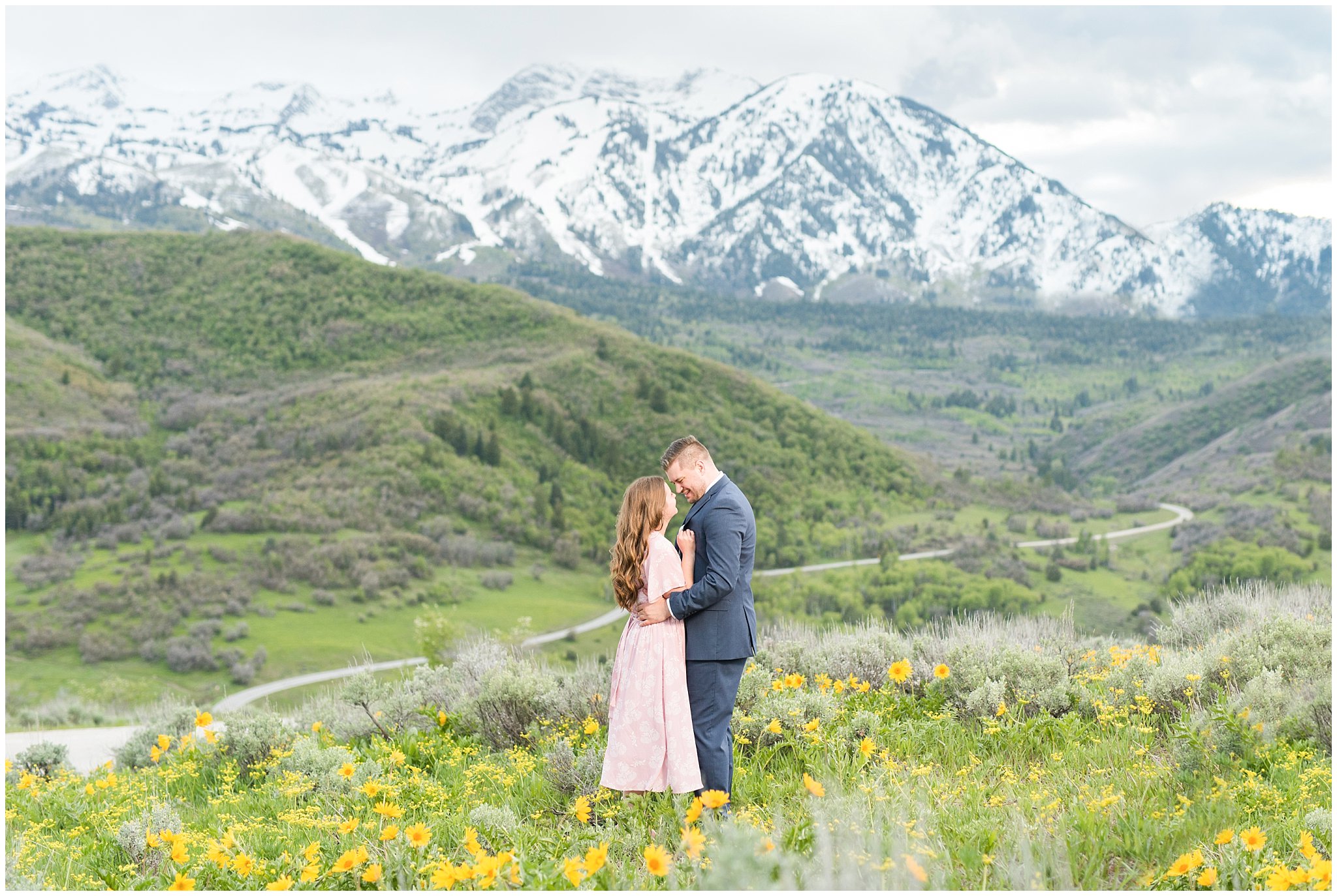 Couple dressed up for formal engagement session in front of snow capped Utah mountains with wildflowers | Top Utah Wedding and Couples Photos 2019 | Jessie and Dallin Photography