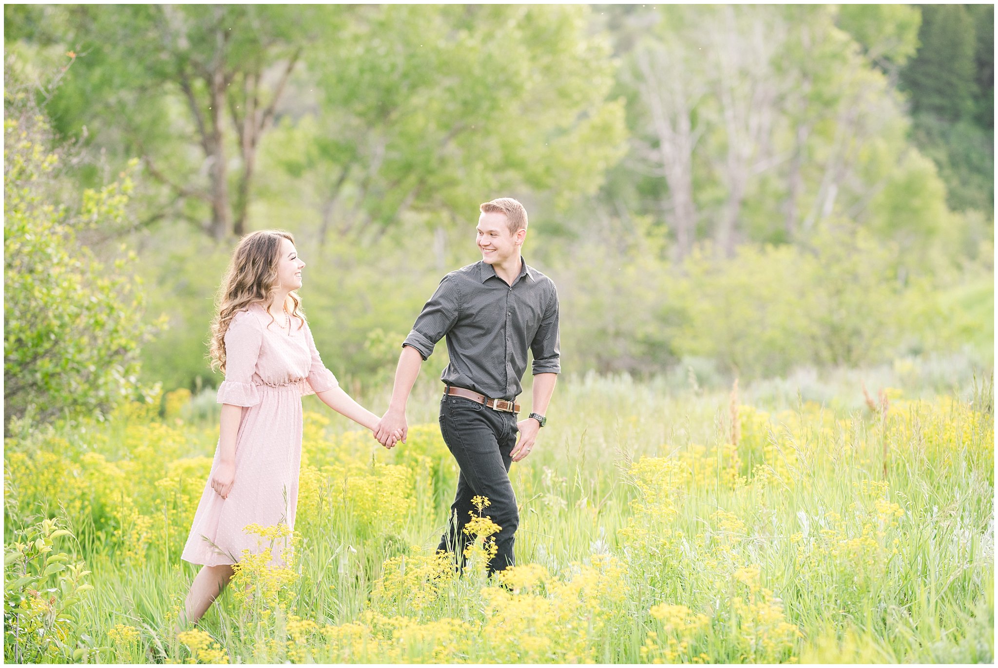 Couple walks through green grasses and yellow wildflowers in the Utah mountains during engagement session | Top Utah Wedding and Couples Photos 2019 | Jessie and Dallin Photography