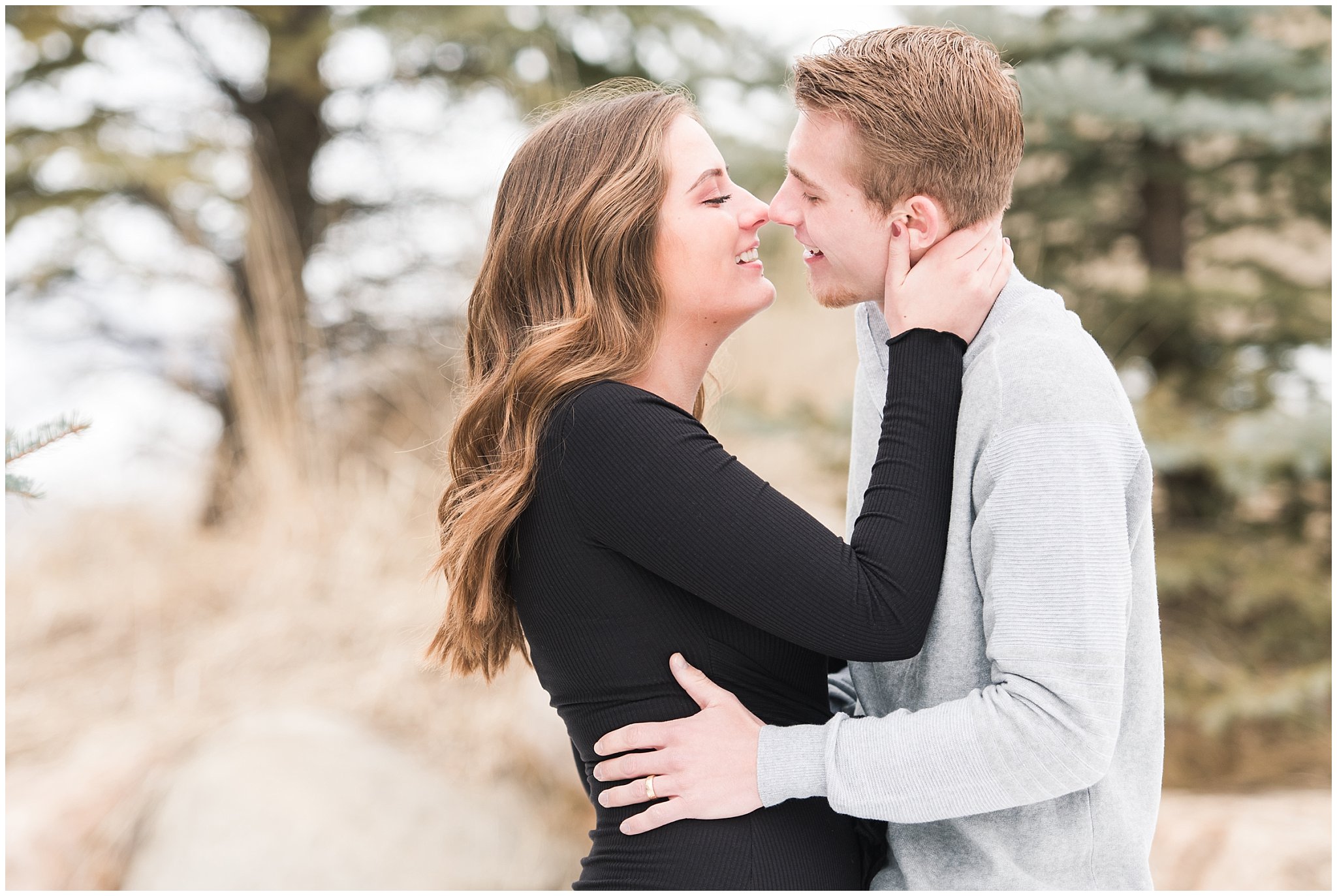 Couple dressed in black dress and grey sweater for engagements in the snowy Utah mountains | Mountain Green Winter Engagement | Jessie and Dallin Photography