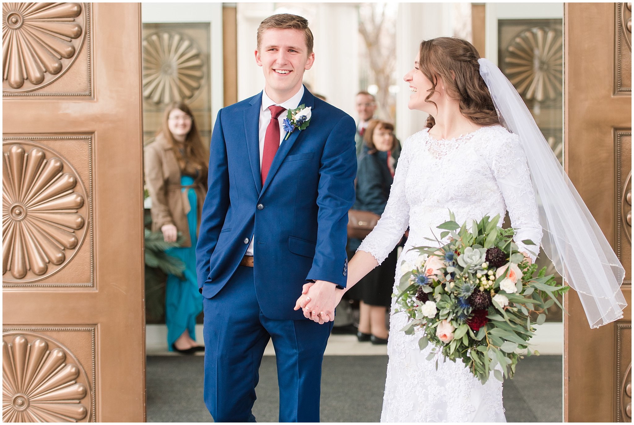 Bride and groom exit the temple with blue suit and burgundy, white and succulent bouquet during winter wedding | Bountiful Temple Wedding and Joseph Smith Memorial Reception | Jessie and Dallin Photography