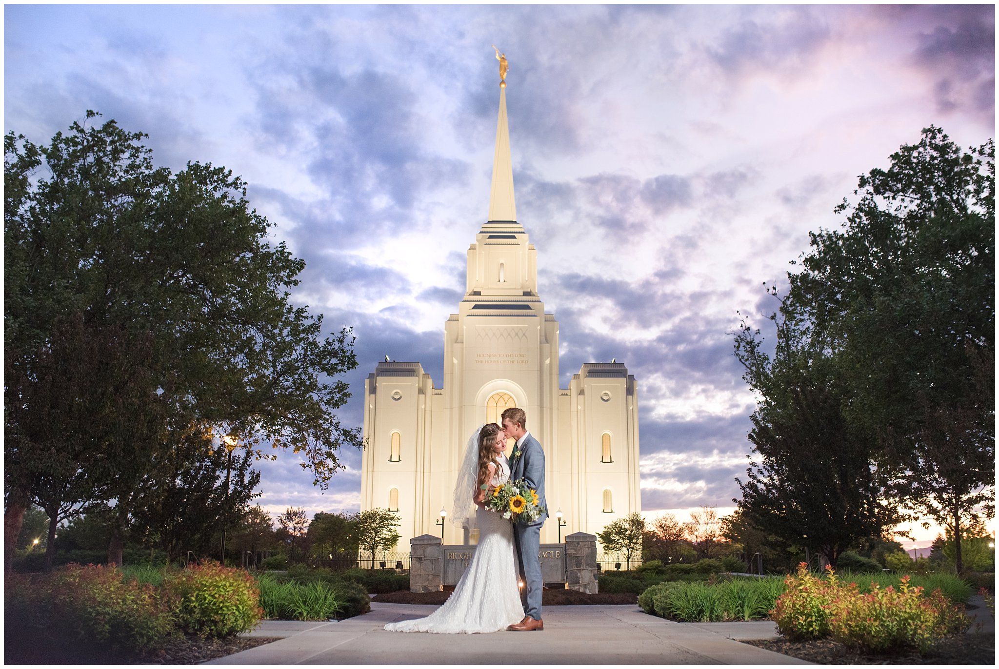 Bride with sunflower and succulent bouquet and groom in light blue suit at the Brigham City Temple at sunset | Brigham City Temple and Mantua Mountain Formal Session | Jessie and Dallin Photography