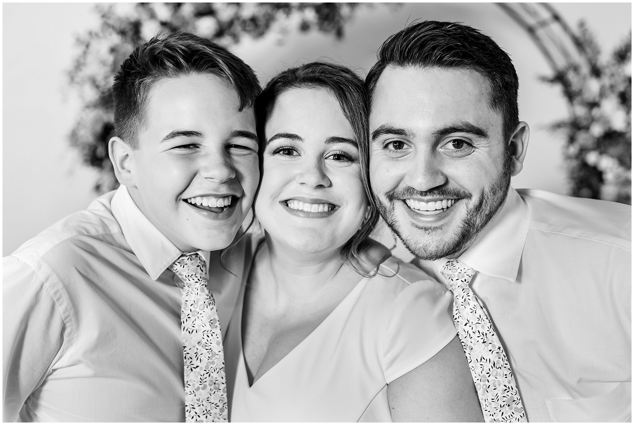 Family portraits in front of floral arch in shades of pink | Talia Event Center Summer Wedding | Jessie and Dallin Photography