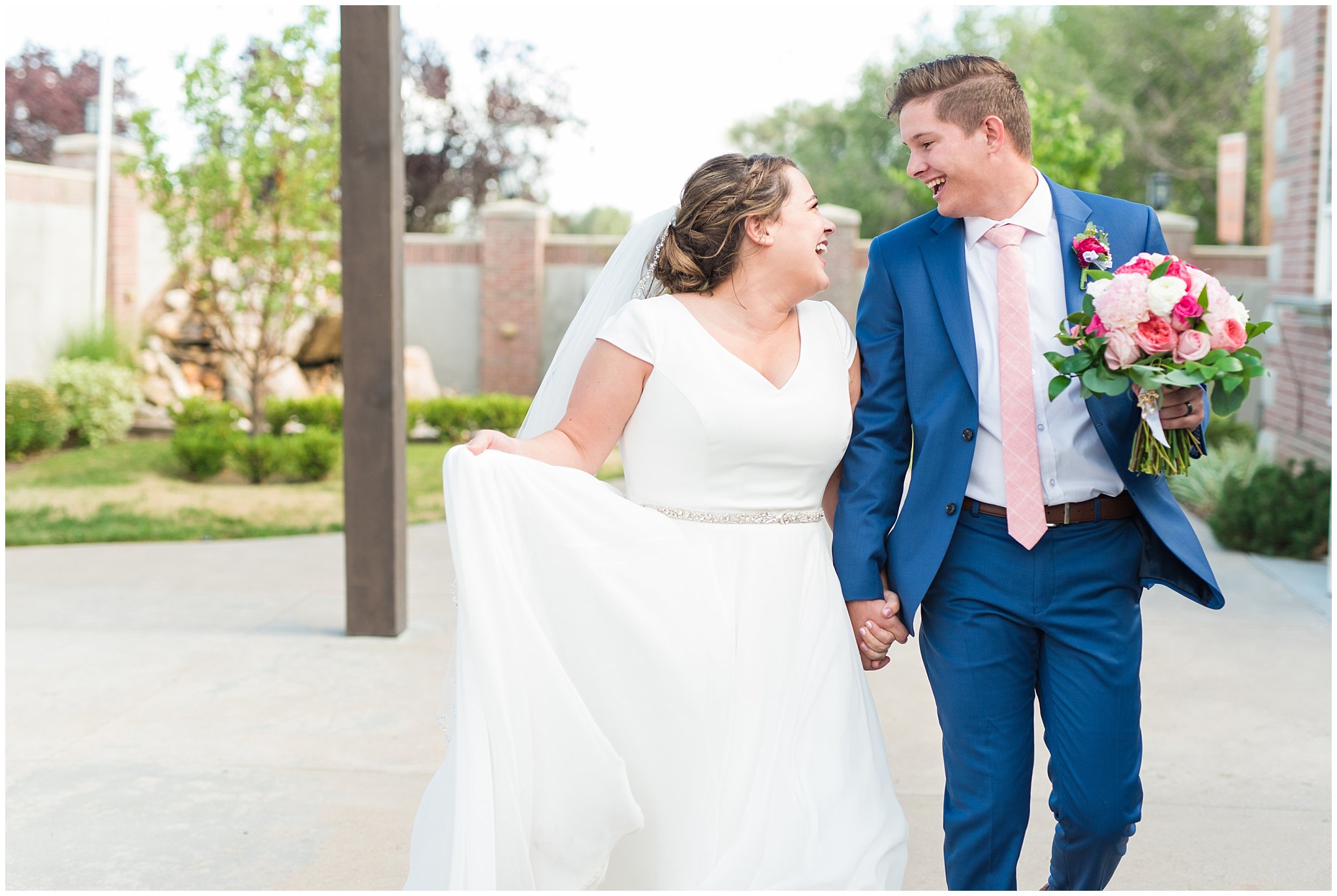 Bride and groom walking in courtyard wearing flowy dress and cornish blue suit | Talia Event Center Summer Wedding | Jessie and Dallin Photography