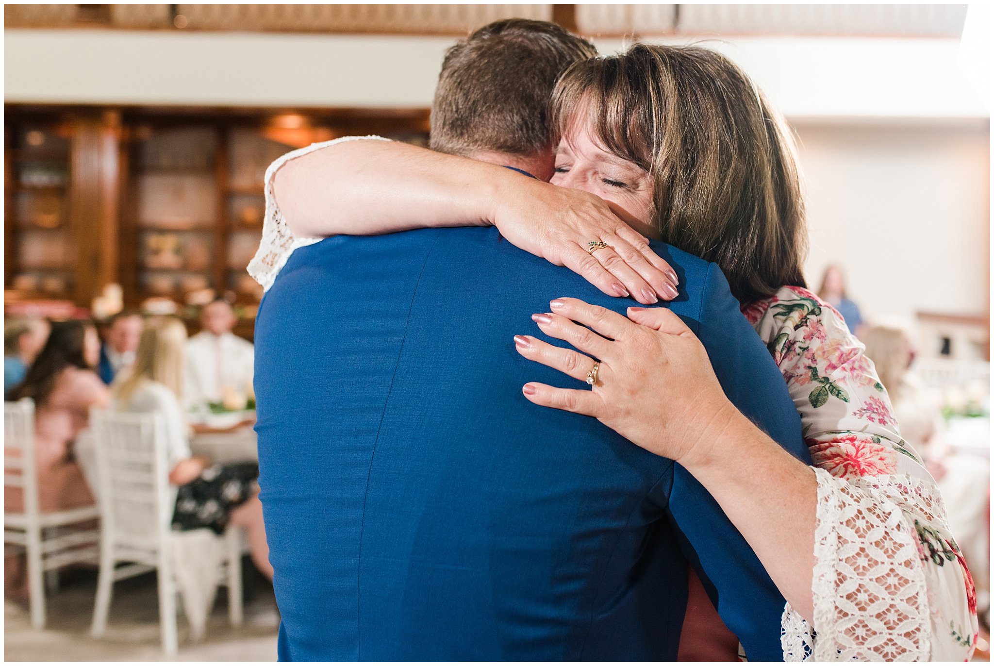 Emotional moments during mother son dance with floral arch in shades of pink | Talia Event Center Summer Wedding | Jessie and Dallin Photography