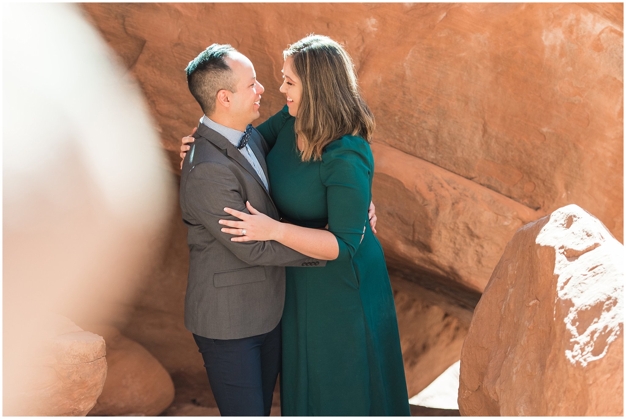 Couple dressed in green dress and grey and blue suit with bowtie for adventure engagement session at Arches National Park and Dead Horse Point Engagement | Jessie and Dallin Photography